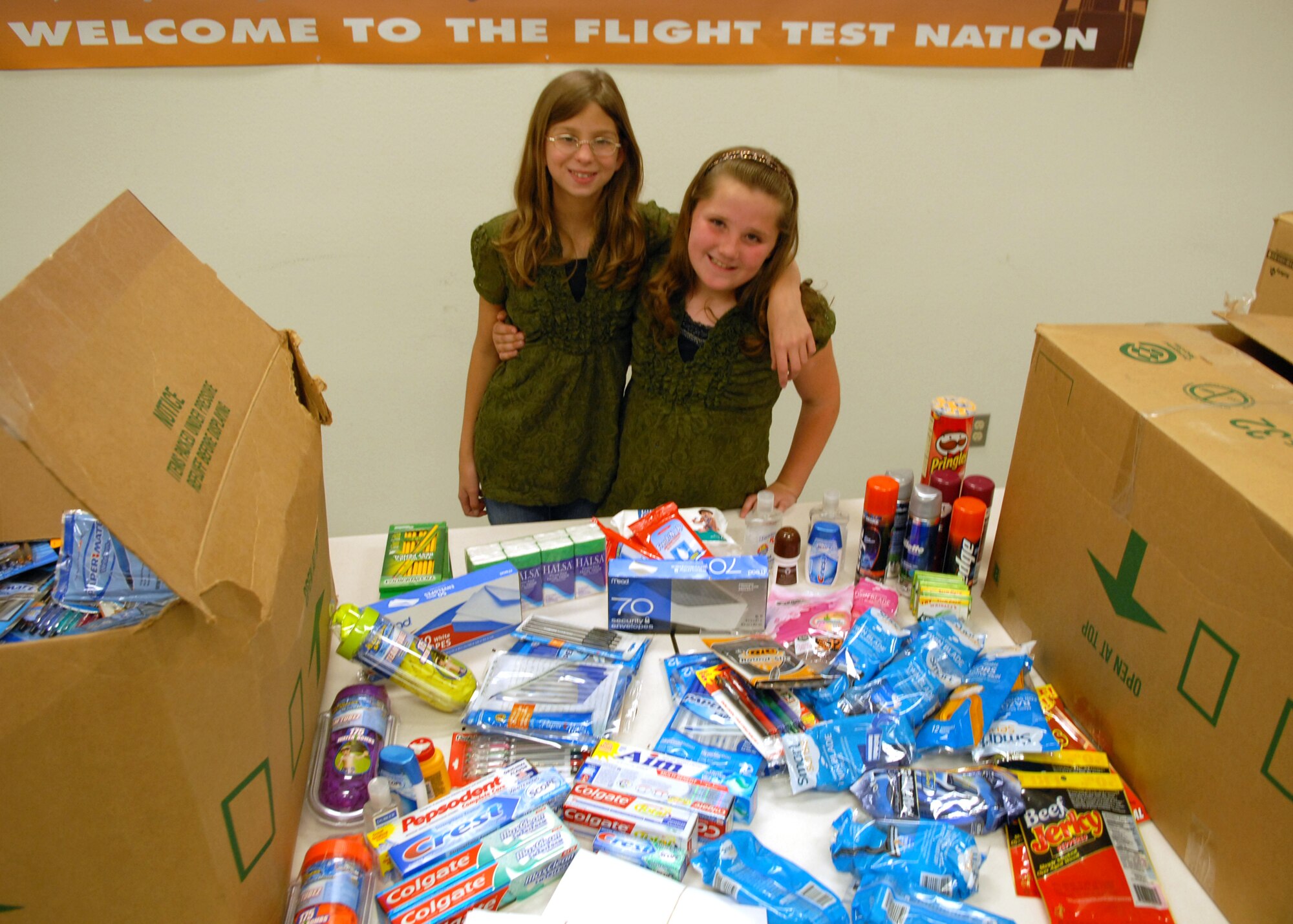 Brittany Sheridan, 12 (right) and Shayla Smith, 8, stand in front of the 5,214 items they collected for deploying troops. The two girls spent May 7 and 8 outside of a K-Mart in Lancaster, Calif. where they solicitated donations from customers in the form of items such as toothpaste, shampoo, crossword books and thank you letters. (Air Force photo by Kate Blais)