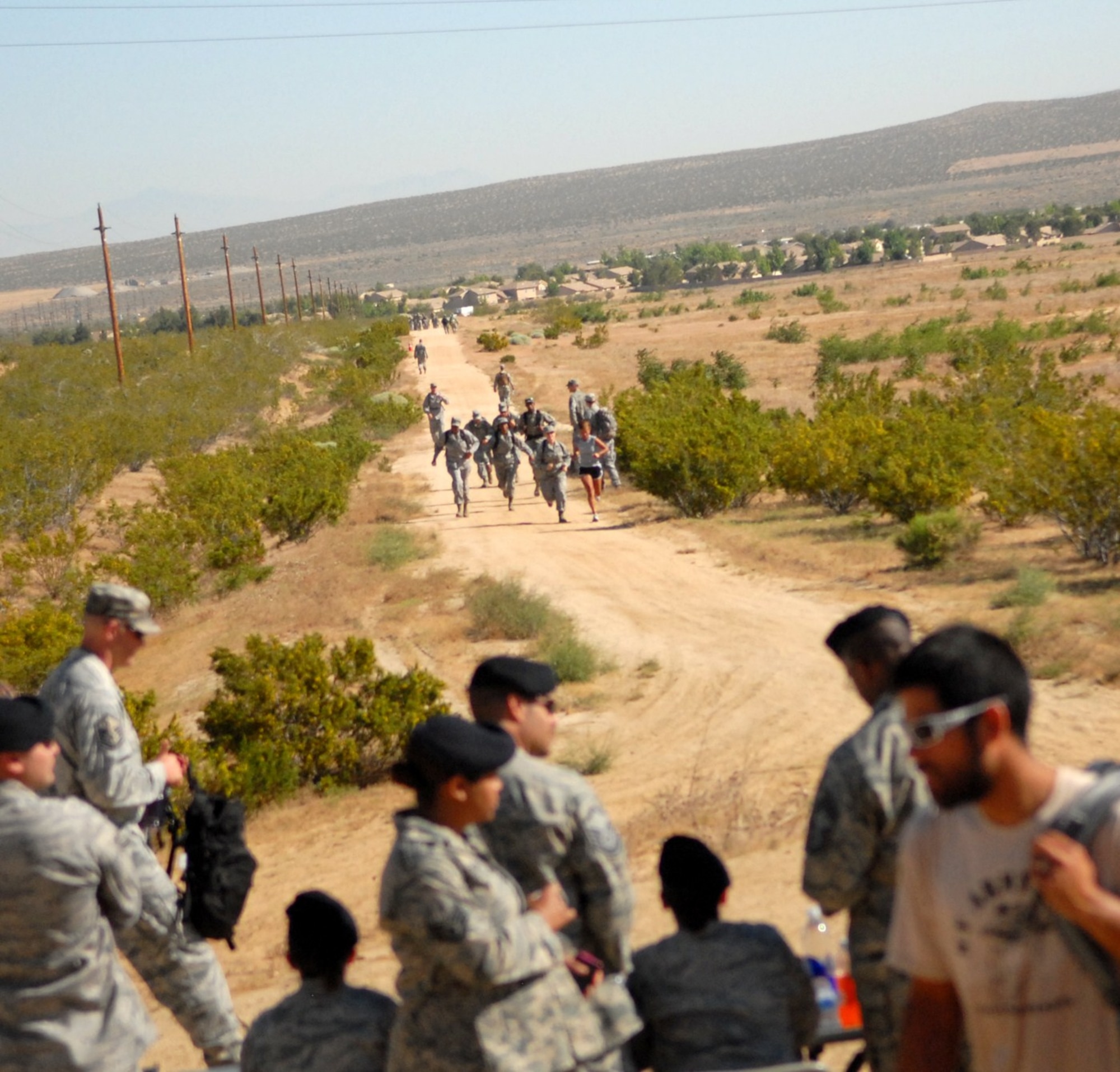 Participants in The Ultimate Sacrifice Memorial Ruck March, May 13, make a final push toward the finish after 7.2 miles of hustling through the desert course beyond base housing. Twenty-seven four- man teams and two individuals competed in this annual event sponsored by the 95th Security Forces Squadron Desert Defenders. The march was held to honor fallen servicemembers. (Air Force photo by Kate Blais)