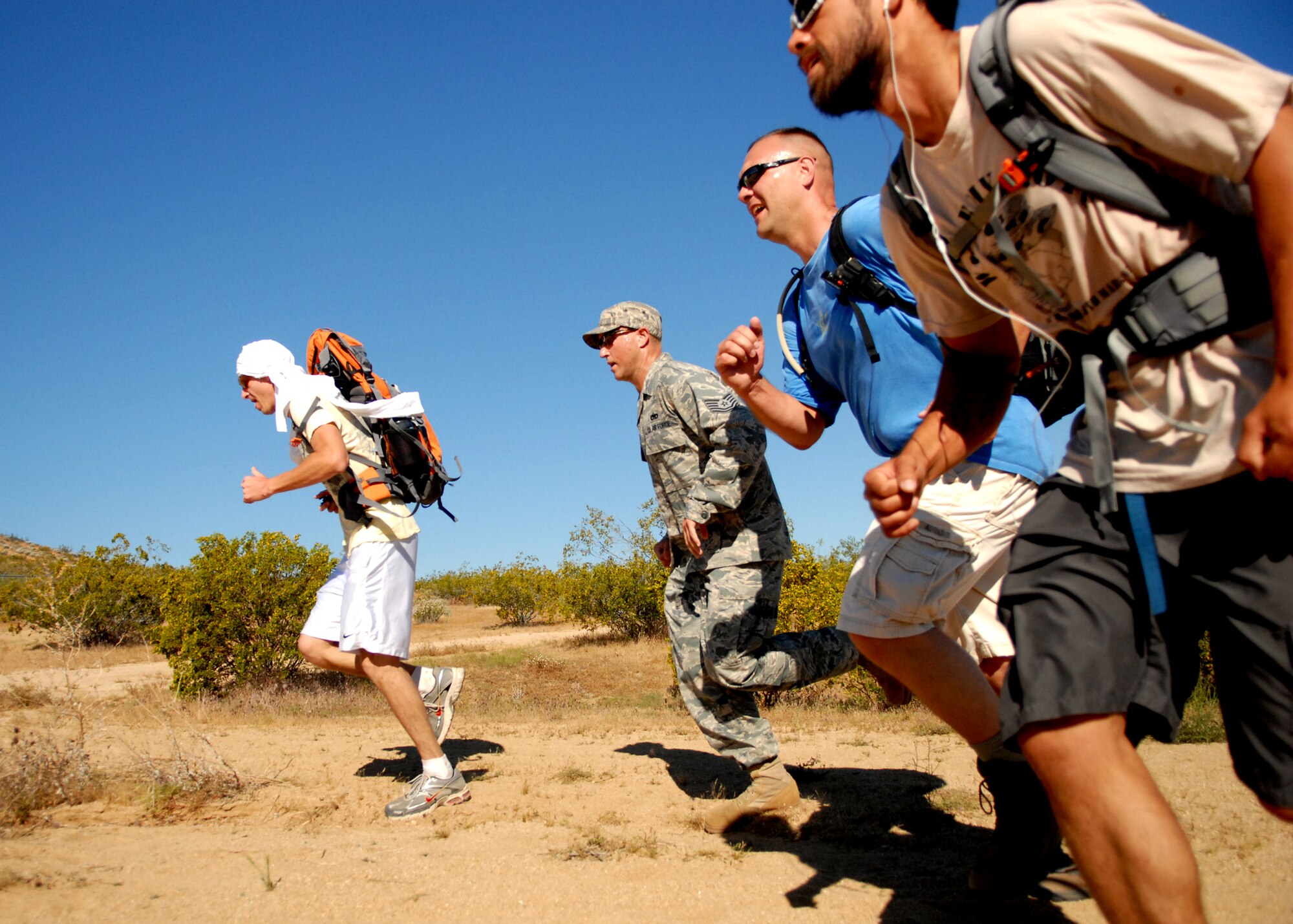 From left, Clayton Steinberg, Tech. Sgt. Eric Grant, Ron VanArsdale and Michael Kelly, all from the 412th Maintenance Squadron AMMO, dash toward the finish line of The Ultimate Sacrifice Memorial Ruck March May 13. The annual event consisted of a 7.2 mile run through desert hills with 35-pound sandbags in the rucksack on the back of each participant. The march was held to honor fallen servicemembers. (Air Force photo by Kate Blais)