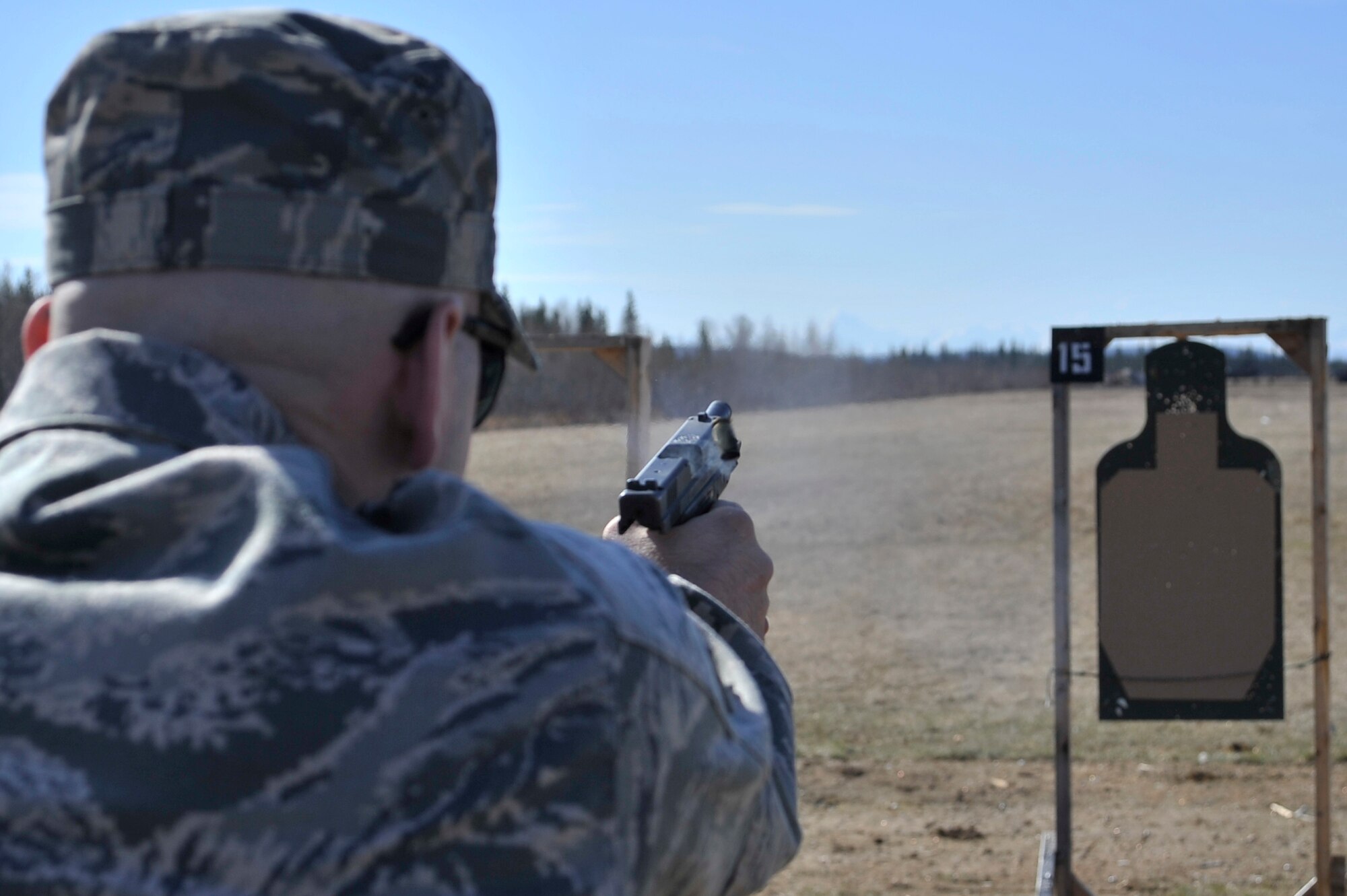 Staff Sgt. Steven Brown competes in a timed firing competition during the National Police Week pistol shoot at the combat arms firing range May 16, 2011, Eielson Air Force Base, Alaska. The week is celebrated across the United States and by Security Forces units abroad to commemorate and honor those who serve as law enforcement officers. Sergeant Brown is the unit deployment manager assigned to the 354th Security Forces Squadron. (U.S. Air Force photo/Staff Sgt. Christopher Boitz)