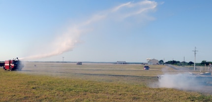 Randolph 902nd CES  Fire Department personnel extinguishes a fire after a simulated T-38  Talon aircraft crash at Randolph's auxiliary field in Seguin ,Texas during  a Joint Base San Antonio exercise  May 17. (U.S. Air Force Photo By Don Lindsey)