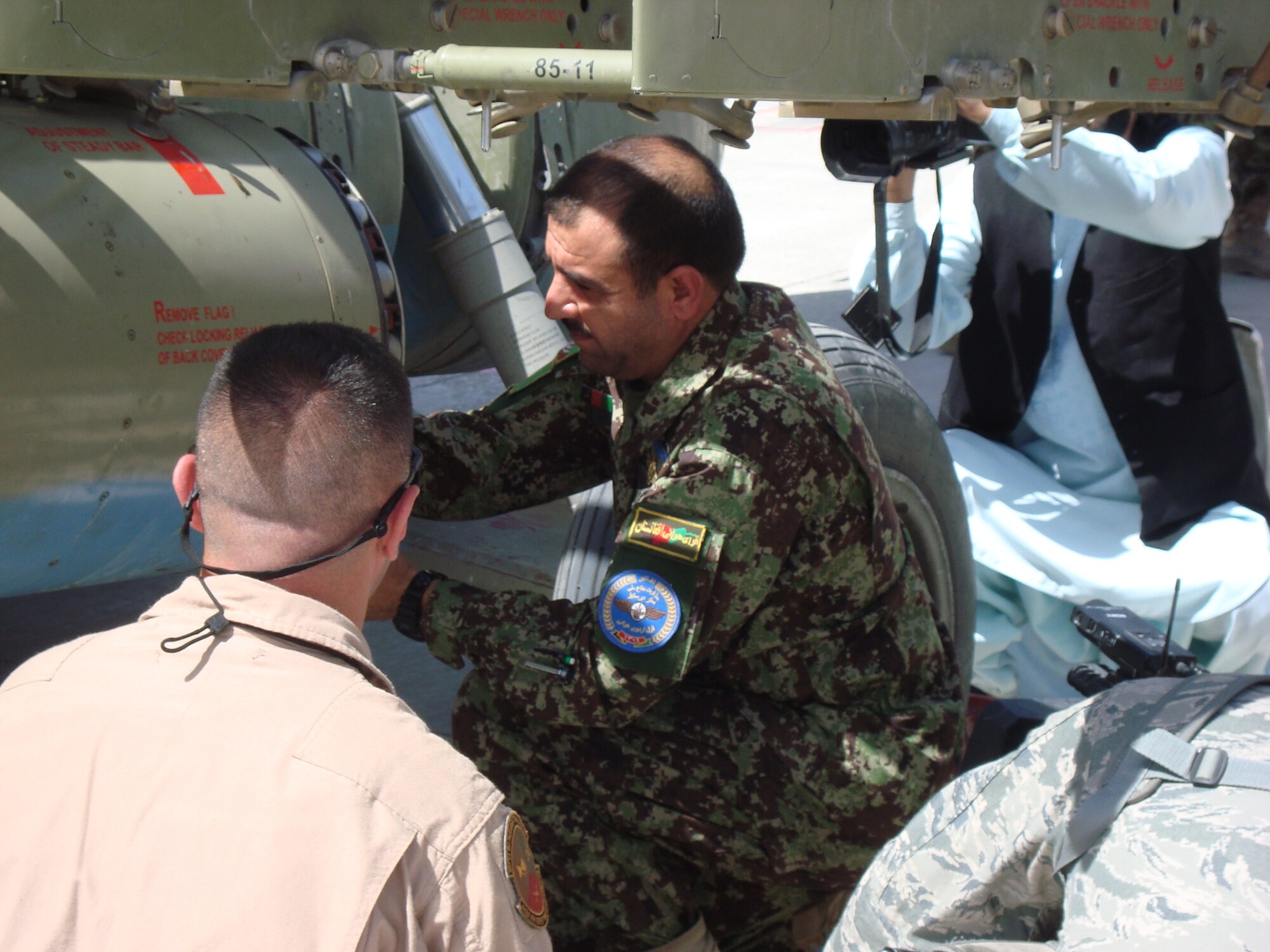 Afghan Air Force Maj Gen Sherzai loads a rocket at the first AAF arming point May 15 on the flightline at Kandahar Airfield. The Kandahar Air Wing reached a milestone May 15 with the opening of the Afghan Mi-17 weapons arming point – a key step towards delivering airpower dominance to both the 205th and 215th Afghan National Army Corps. (U.S. Air Force courtesy photo)
