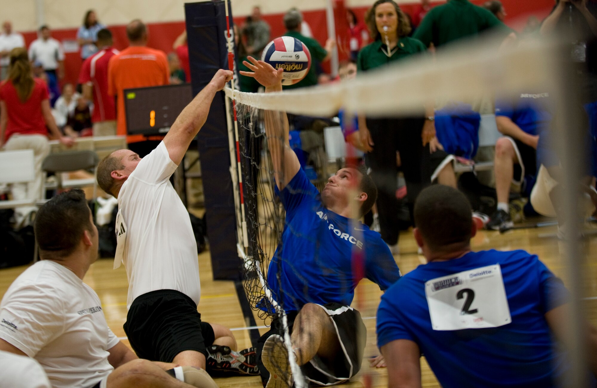 A member from the United States Special Operations Command teams knocks the ball past an Air Force defender during sitting volleyball competition at the 2011 Warrior Games in Colorado Springs, Colo. The Air Force played the U.S. Special Operations Command team, losing the series 2 games to 1. (U.S. Air Force photo/Staff Sgt. Christopher Griffin)
