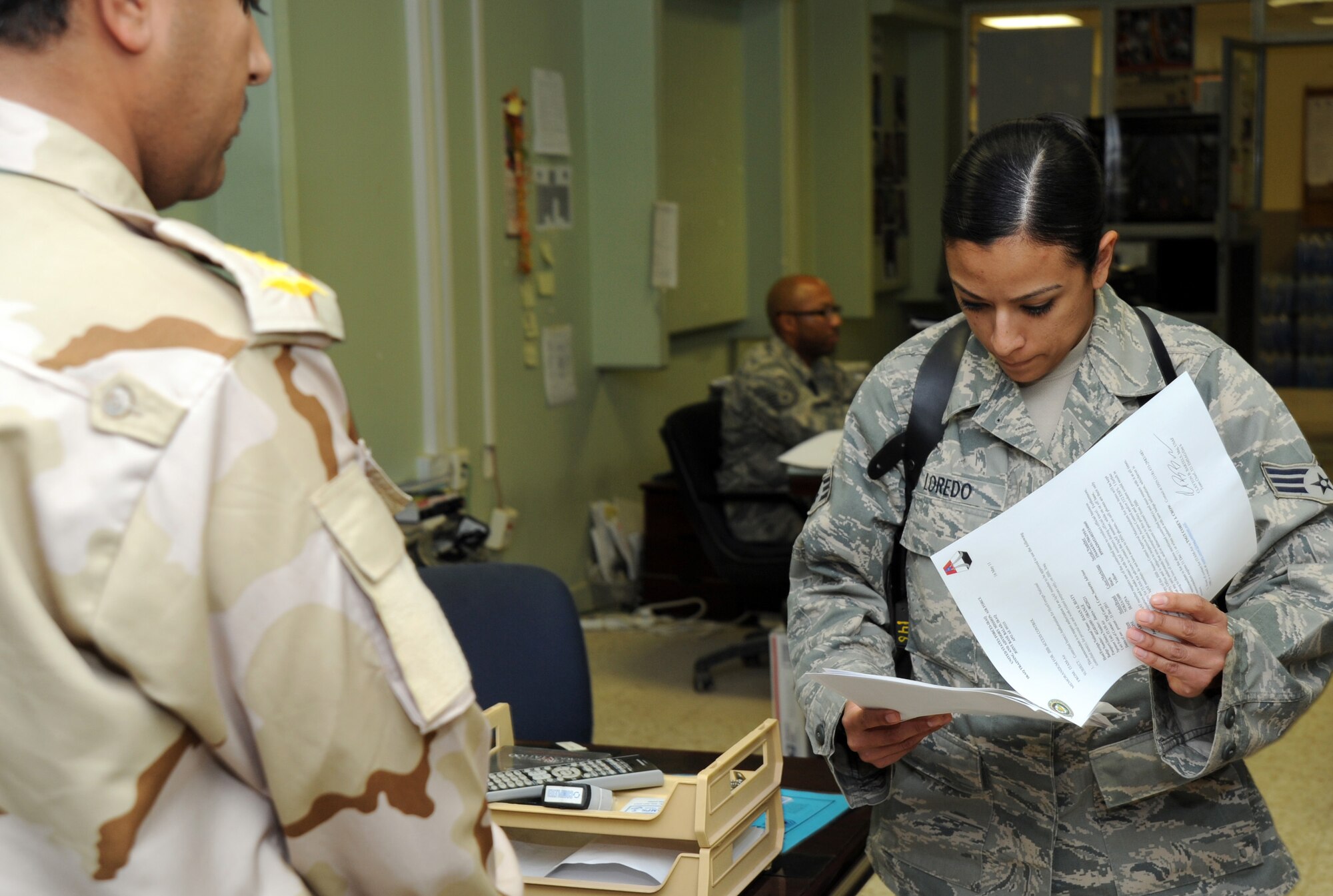JOINT BASE BALAD, Iraq--Senior Airman Maria Loredo, 332nd Expeditionary Security Forces Squadron access control, reviews paperwork prior to in-processing Iraqi Air Force advance echelon (ADVON) personnel May 17, 2011. The ADVON team recently arrived here to eventually receive the base from U.S. Forces. Airman Loredo is deployed from Joint Base Andrews, Md., and is a native of Pomona, Calif. (U.S. Air Force photo/Staff Sgt. Keyonna Fennell)  