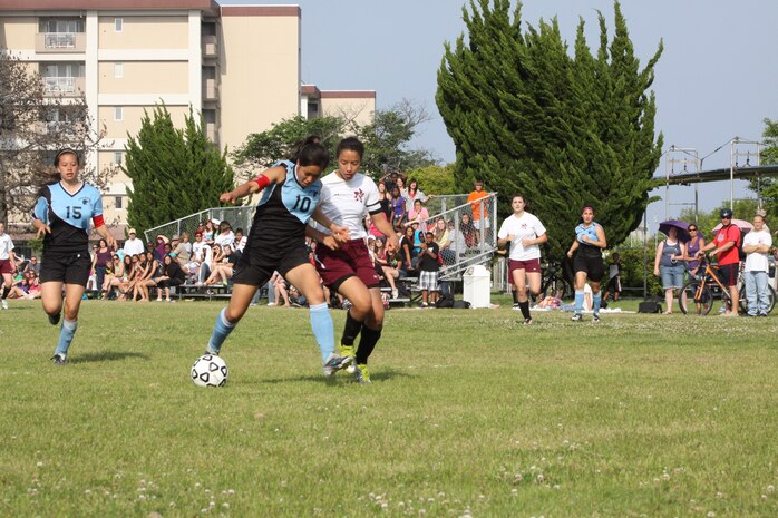 Bre’Onna R. Ray, Matthew C. Perry girls soccer team captain and forward, attempts to retrieve the ball from Lydia Kim, Osan American High School girls soccer team captain and midfielder, during the Department of Defense Dependent Schools 2011 Division II Far East Girls Soccer Tournament championship game held at the M.C. Perry soccer field here May 19. Osan took the tournament title 2-1 in penalty kicks after both teams fought valiantly to a 0-0 finish in regulation.