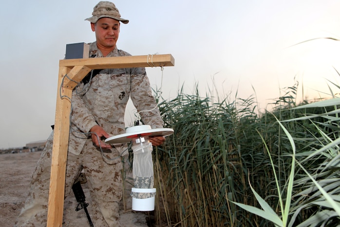 Seaman Charles A. Hill, from Albuquerque, N.M., a preventive medicine technician with the Public Health and Preventive Medicine Detachment, Alpha Surgical Company, 2nd Marine Logistics Group (Forward), sets up a mosquito trap May 19, 2011, aboard Camp Leatherneck, Afghanistan.  The crew sets the traps around the base in strategic places where they suspect insects will breed to collect data and prevent further reproduction and infection effecting troops supporting International Security Assistance Force operations.