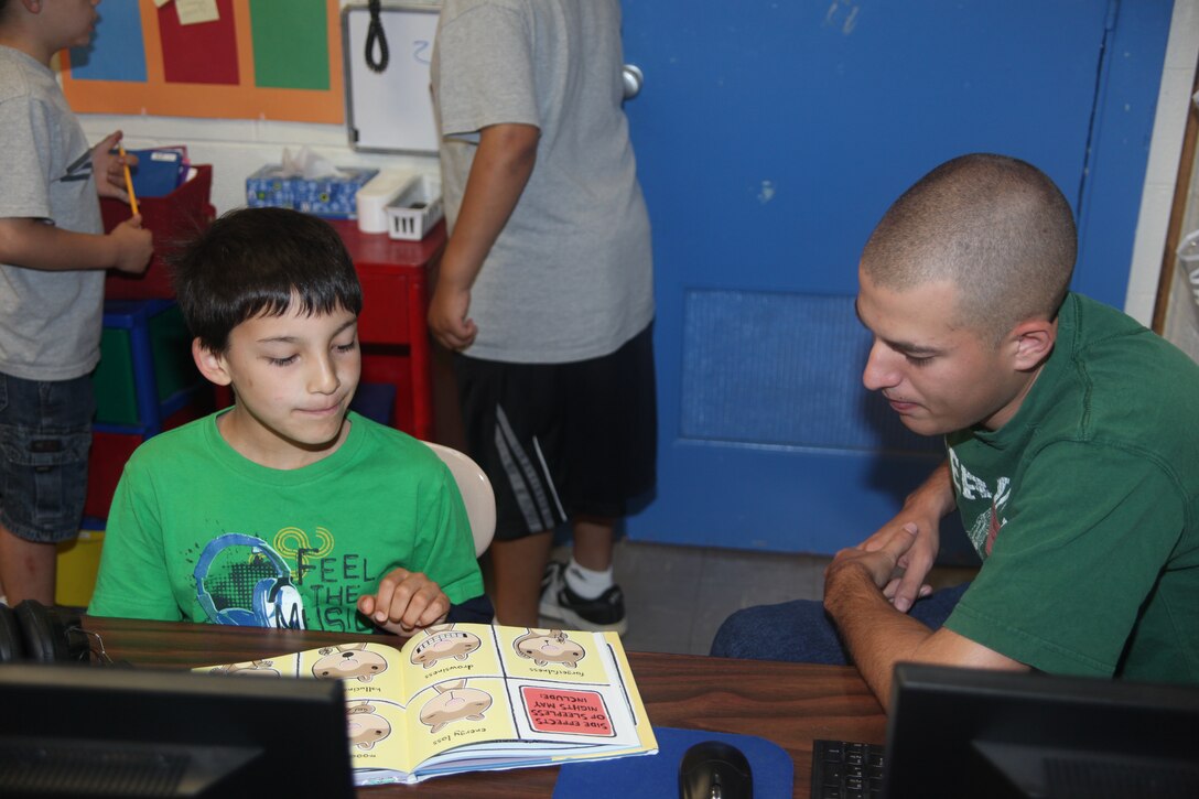 Second-grade student Ben, left, reads a book out loud to Cpl. Cary T. Farrington at Arthur Edwards Elementary School May 19. Farrington, a refueler with Marine Wing Support Squadron 271, and more than five other Marines helped teachers proctor elementary students during their end-of-grade exams May 18-19. “I feel it is most important to volunteer at schools because it helps out the kids and the teachers,” said Lance Cpl. John M. McDonough, a supply clerk with MWSS-271. “These kids are like us Marines. They come from all over to Cherry Point, and our volunteering helps give them a chance at a better education.”