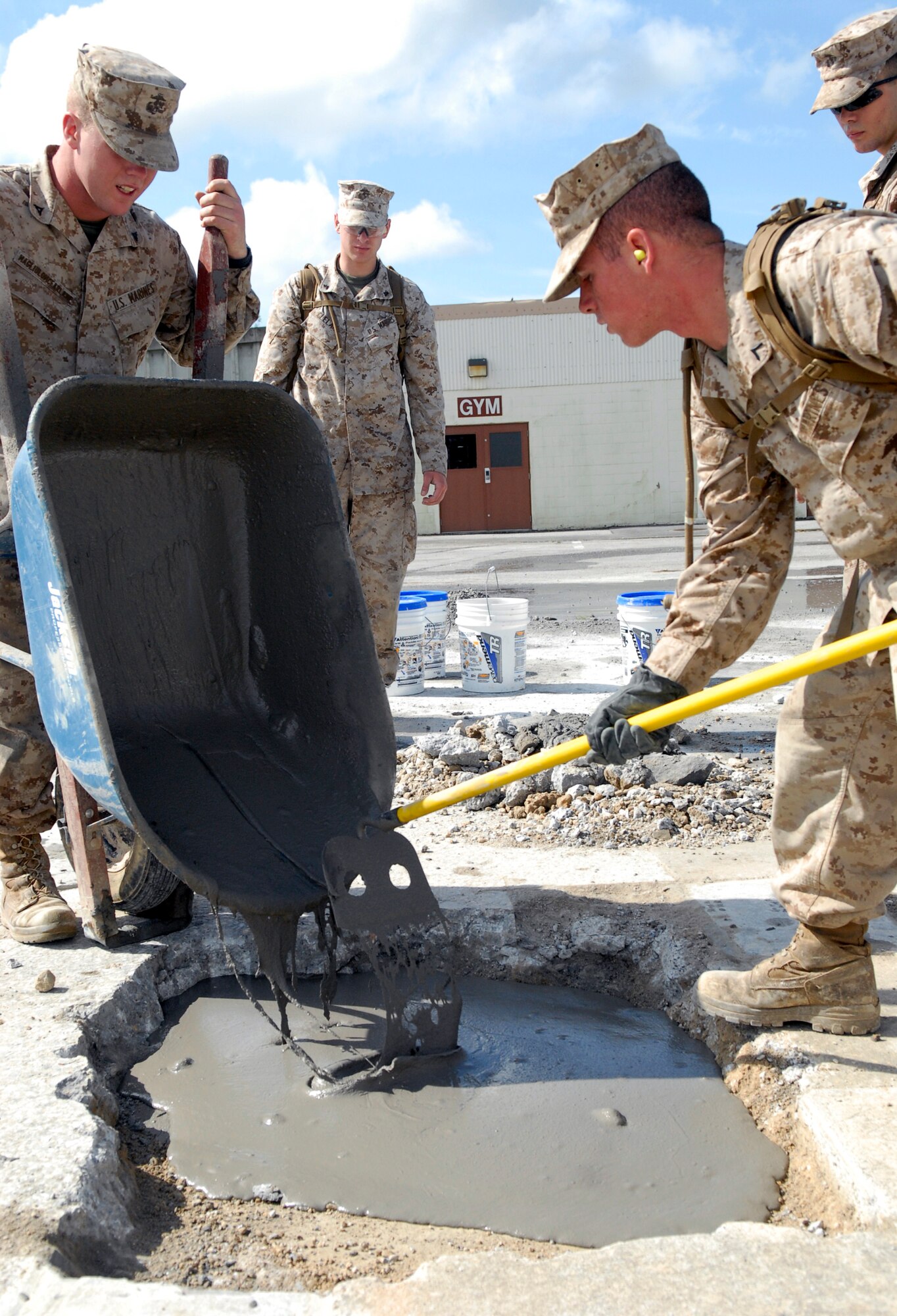 Marines assigned to Camp Foster's Marine Wing Support Squadron 172 pour quick-drying cement as they work against the clock to repair spalled concrete at Kadena's Silver Flag site. The air base's 554th RED HORSE Squadron hosted a week-long training camp for the Marines, teaching techniques in heavy equipment operation and rapid runway repair methods unique to the Air Force. (U.S. Air Force photo/Airman 1st Class Tara A. Williamson)