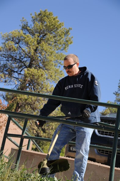 CLOUDCROFT, N.M. --  A member of Basic Expeditionary Airfield Resources Base weed-wacks, May 13, 2011, outside of the Cloudcroft Elementary School during the Day of Caring. Members of Holloman Air Force Base’s BEAR Base teamed up to beautify the small mountain community of Cloudcroft as part of the annual volunteer event. The Day of Caring, hosted by the Otero County United Way, is designed to assist the local community and community members in need. (U.S. Air Force photo by Senior Airman Sondra Escutia/Released) 