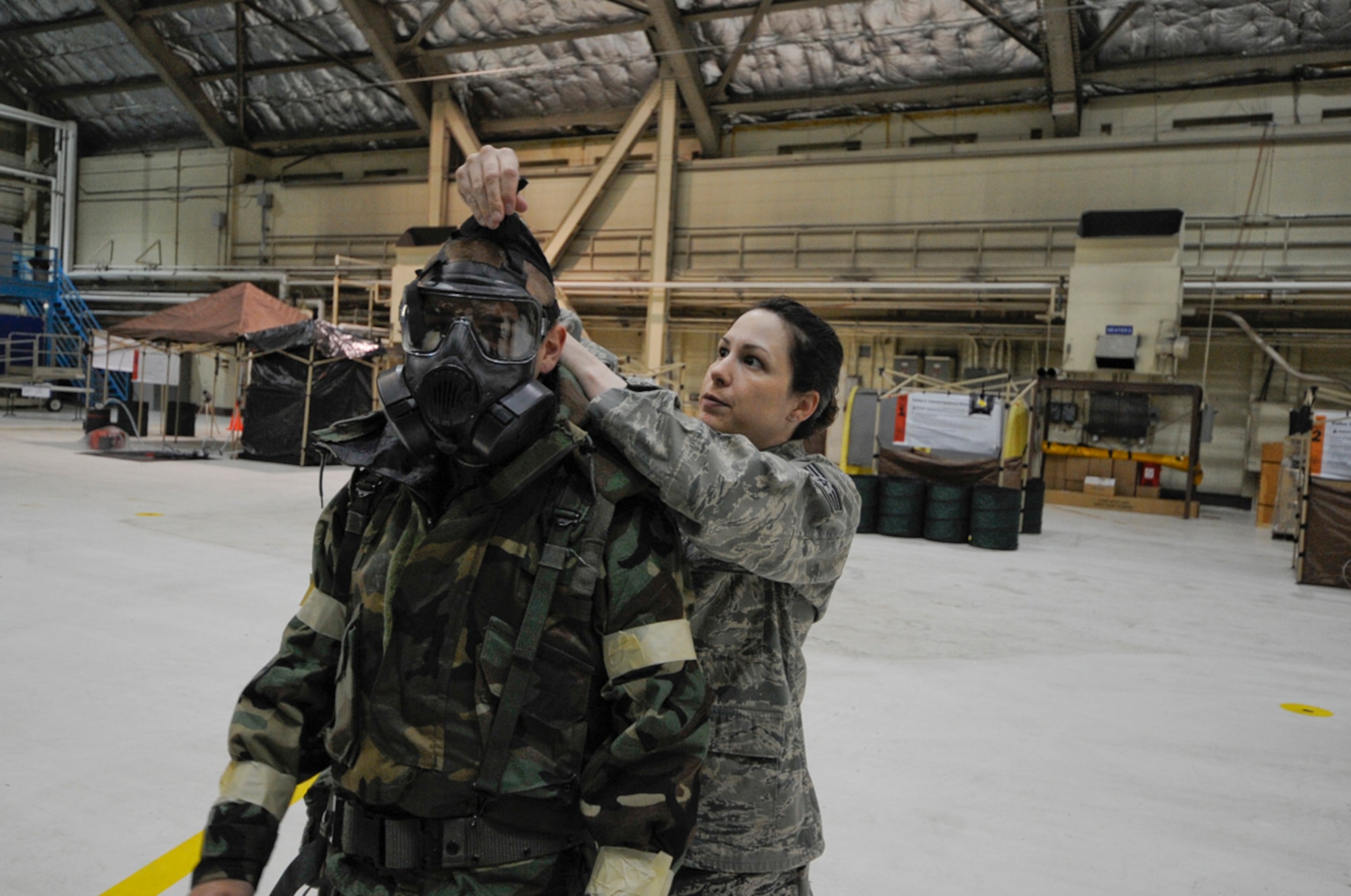 SSgt Kandice Nolan, 673 ABW/CEX, Joint Base Elmendorf-Richardson, Anchorage, Alaska, checks for fit of gas mask during Ability to Survive and Operate Training. (U.S. Air Force photo/Steve White)