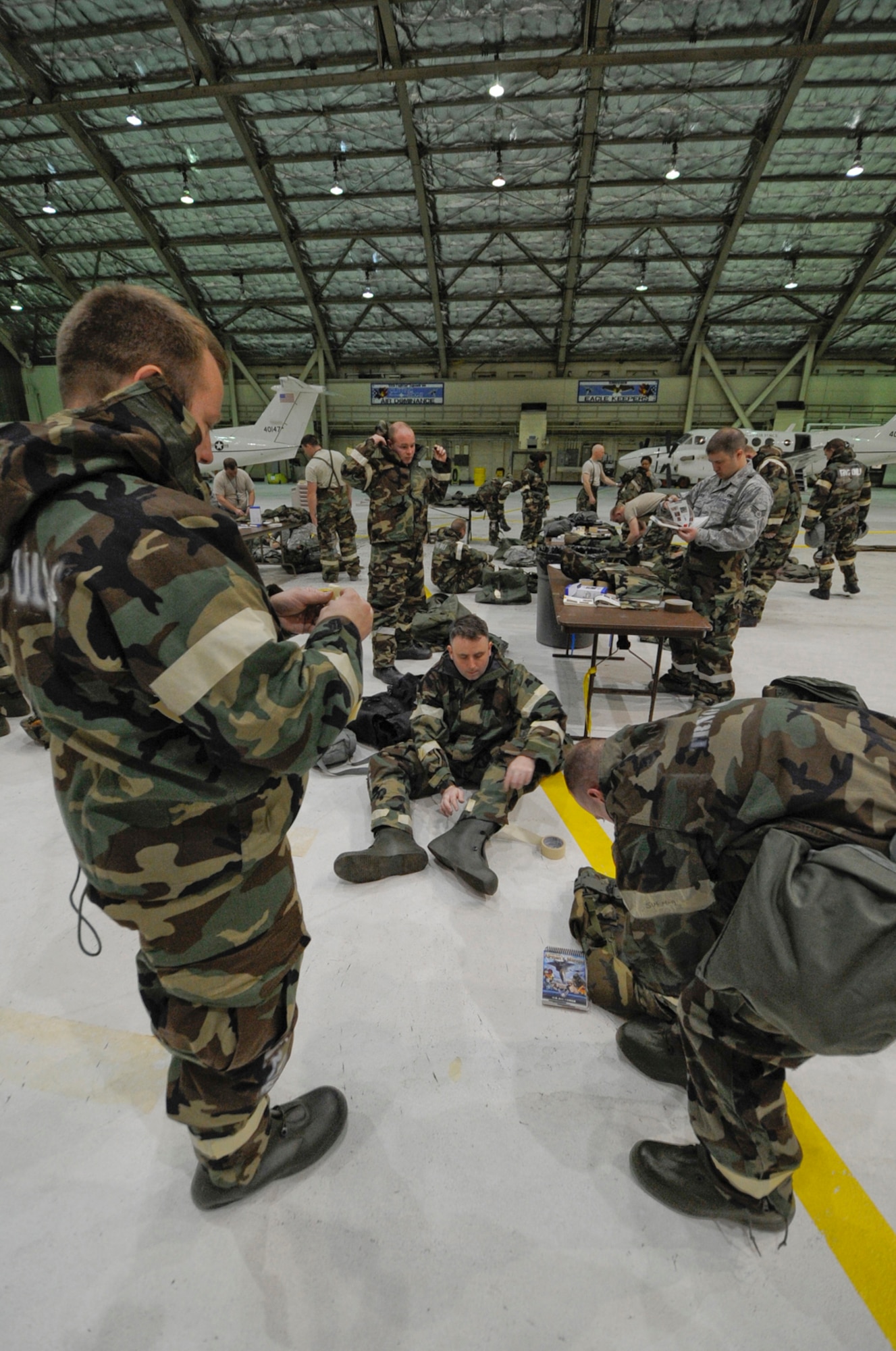 Airmen assigned to the 673 ABW don training CBN suits  during Ability to Survive and Operate Training at Joint Base Elmendorf-Richardson, Anchorage, Alaska. (U.S. Air Force photo/Steve White)