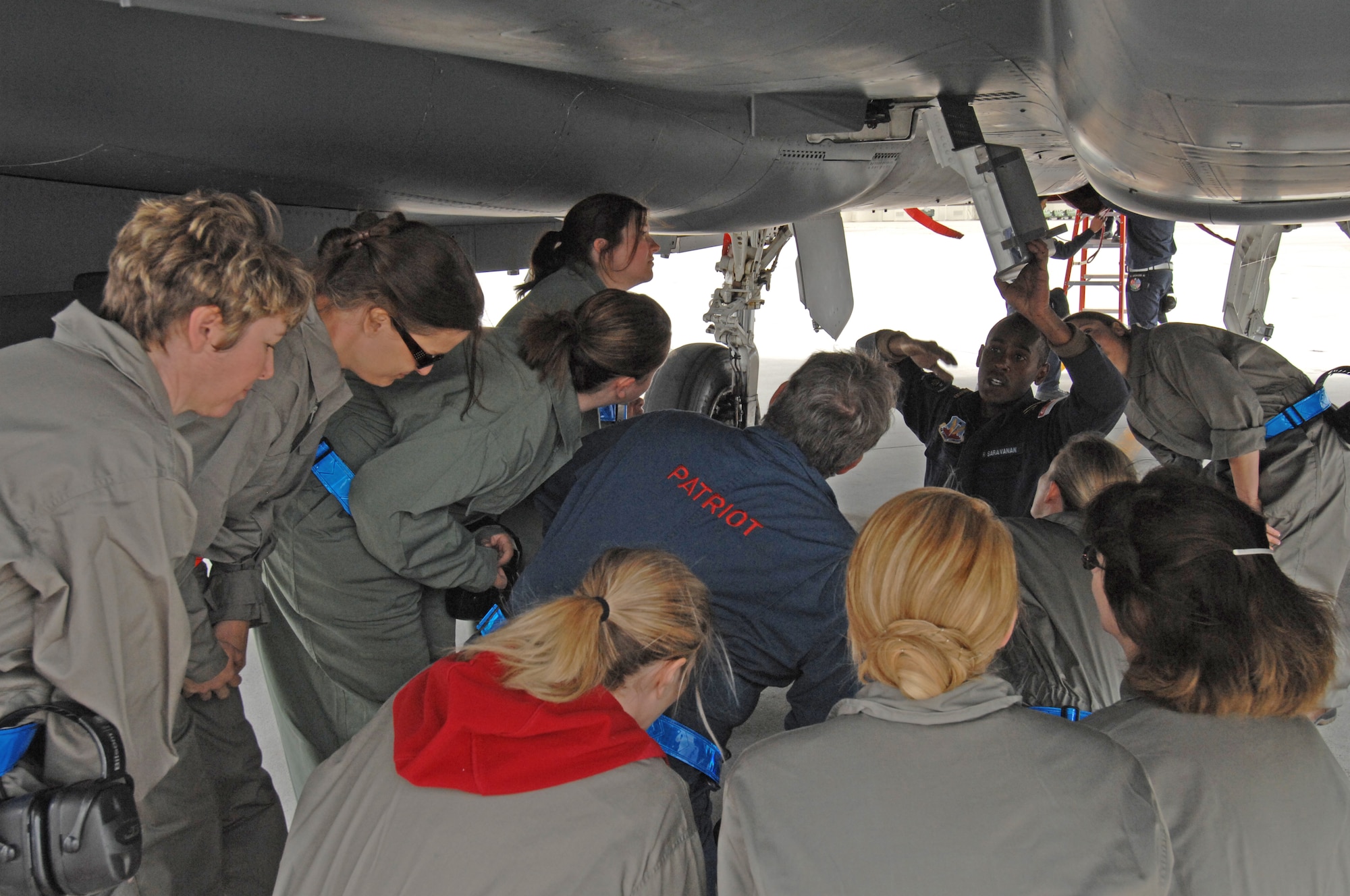 MOUNTAIN HOME AIR FORCE BASE, Idaho – Republic of Singapore Air Force crew chief R. Saravanan explains how ammunition is loaded into the bottom of a F-15SG, to members of the wings senior leadership spouses here May 16. The spouses who participated in the event were allowed access to the flightline to see the intricate workings of the aircraft as well as how the air crews operate as a unit. (U.S. Air Force photo by Senior Airman Benjamin Sutton)