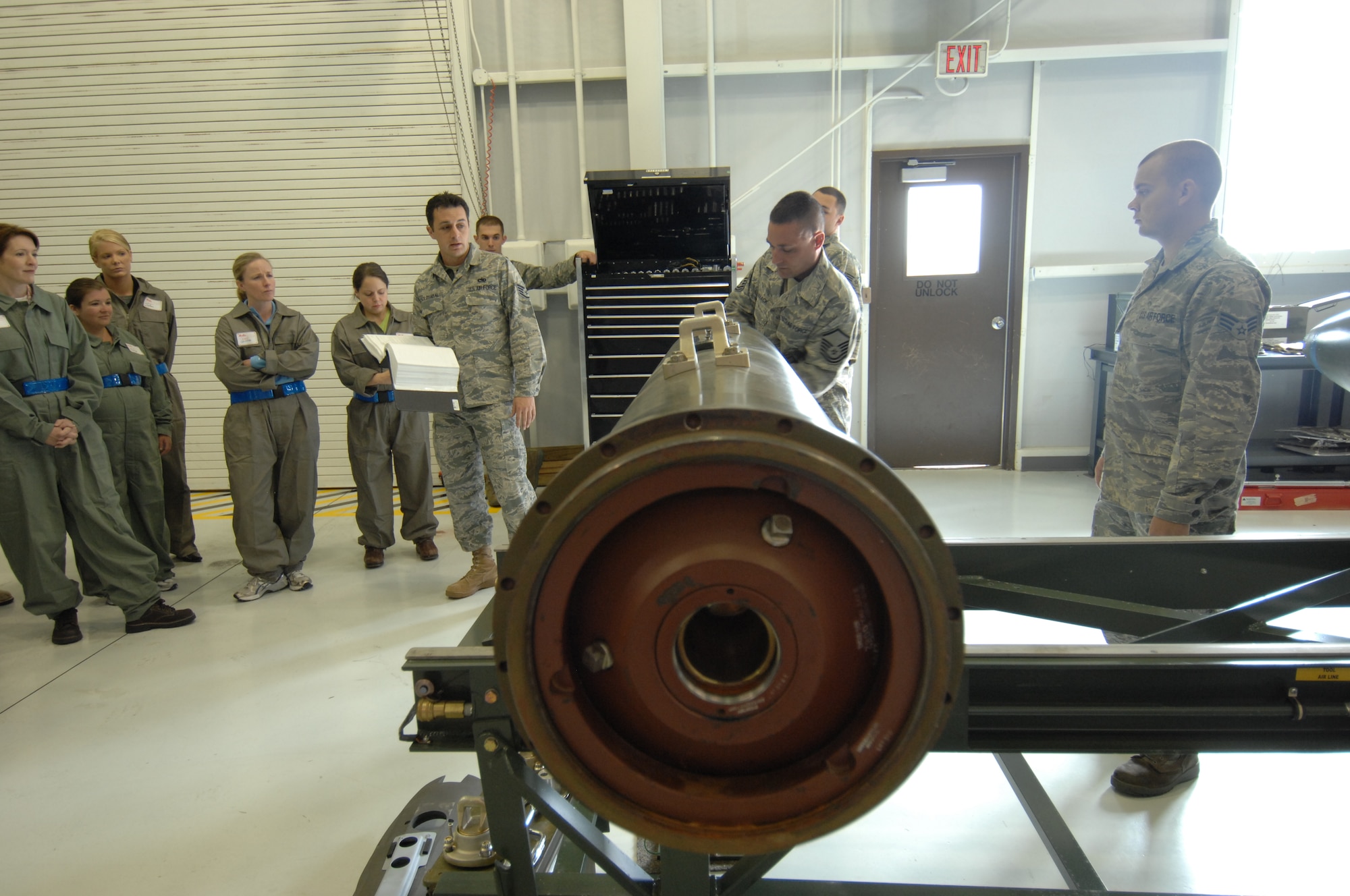 MOUNTAIN HOME AIR FORCE BASE, Idaho – Master Sgt. Robert P. Maack, 366th Equipment Maintenance Squadron munitions inspector, demonstrates munition assembly while Staff Sgt. Erik G. Solosabal, 366th EMS, explains the detailed instructions with which Airmen of the 366th EMS must follow in order to put together a Ground Busting Unit-31 Joint Direct Attack Munition here May 16. Wing senior leadership spouses were given the rare opportunity of witnessing different types of munitions being assembled. (U.S. Air Force photo by Senior Airman Benjamin Sutton)