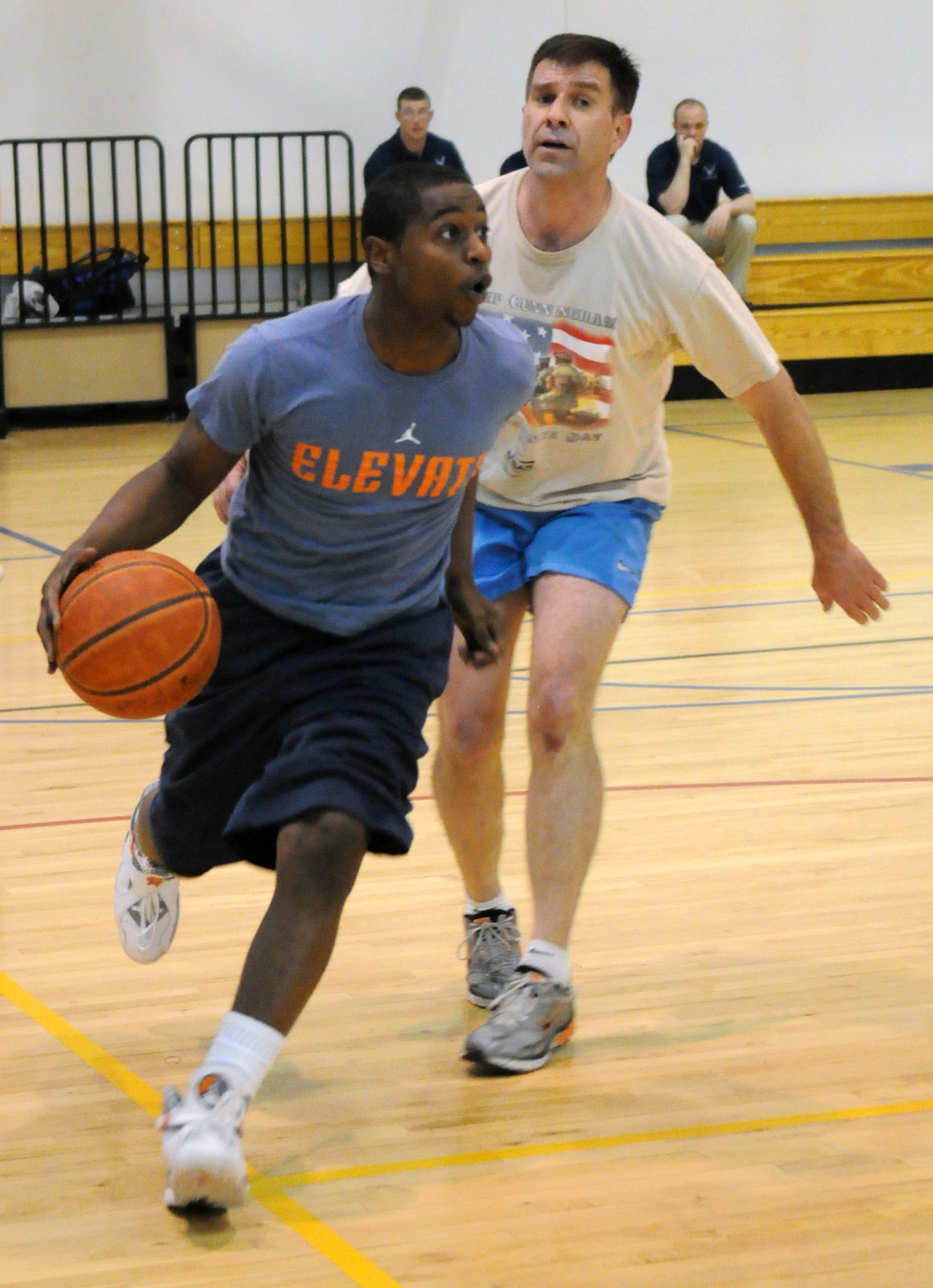 Dirty 30’s Airman Corey Walker, 30th Airlift Squadron, goes past the No Name’s Capt. Brad Kimble, 90th Missile Wing chaplains office, during their 3-on-3 basketball game as part of Fitness Day at Freedom Hall Wednesday, May 11. The Dirty 30, made up of members of the 30th Airlift Squadron, went on to win the round-robin tournament.  (U.S. Air Force photo by R.J. Oriez)