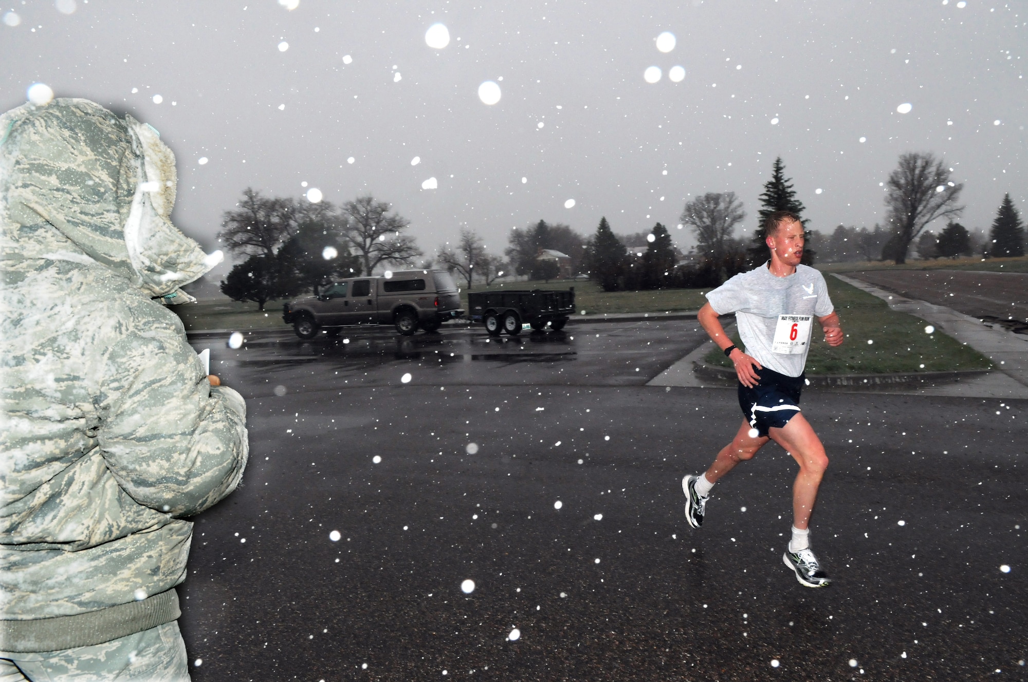 Airman 1st Class Mark Currell, 319th Missile Squadron, crosses the finishing line winning the Fitness Day 5K race in the early morning snow May 11. Airman Currell crossed the line with a time of 15:44. (U.S. Air Force photo by R.J. Oriez)