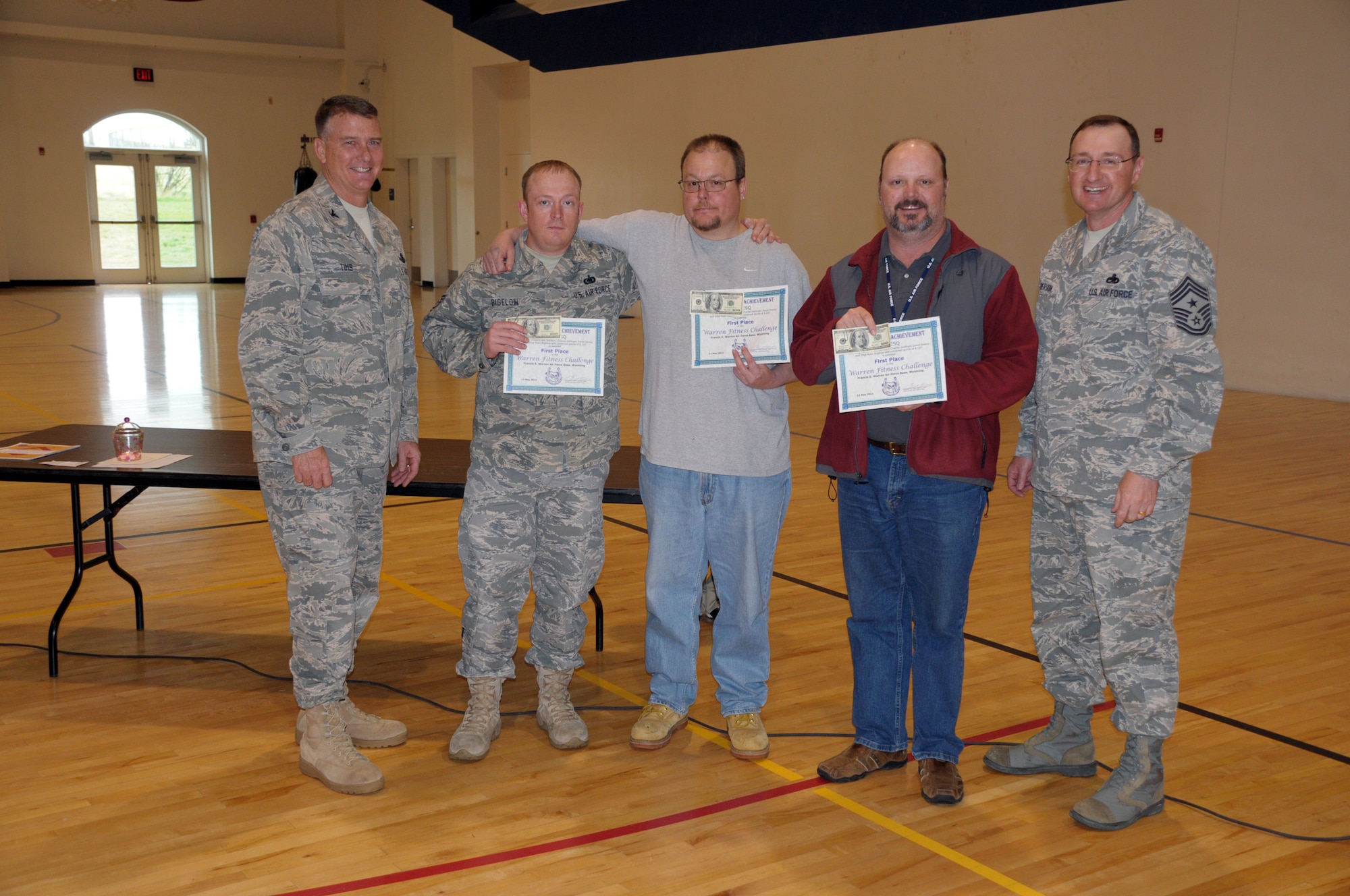 Col. Greg Tims, 90th Missile Wing commander, and Chief Master Sgt. Marty Anderson, 90th MW command chief, present team ESQ - Extra Smooth Quality their first-place award in the first annual Warren Fitness Challenge in the Freedom Hall Fitness Center May 11. (U.S. Air Force photo by Blaze Lipowski)