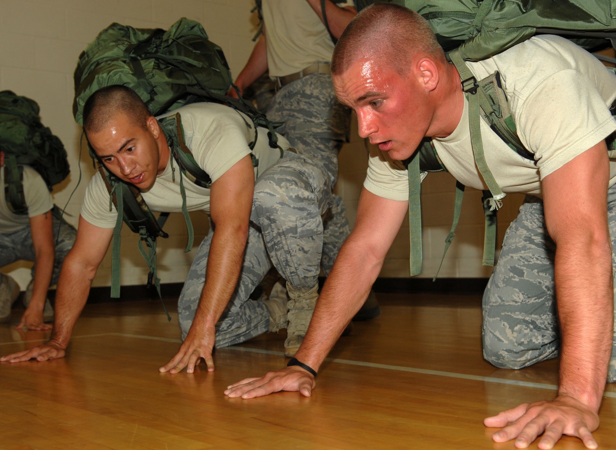 Senior Airman Tyler Wiseman and Airman 1st Class Steven Barnosky, 633d Security Forces Squadron canine handlers, perform rucksack push-ups during the 633d Security Forces Squadron Strong Team Competition at Langley Air Force Base, Va., May 18, 2011.  The competition was held as part of National Police Week, in order to honor military and civilian defenders. (U.S. Air Force photo by Staff Sgt. Jeff Nevison)(RELEASED)