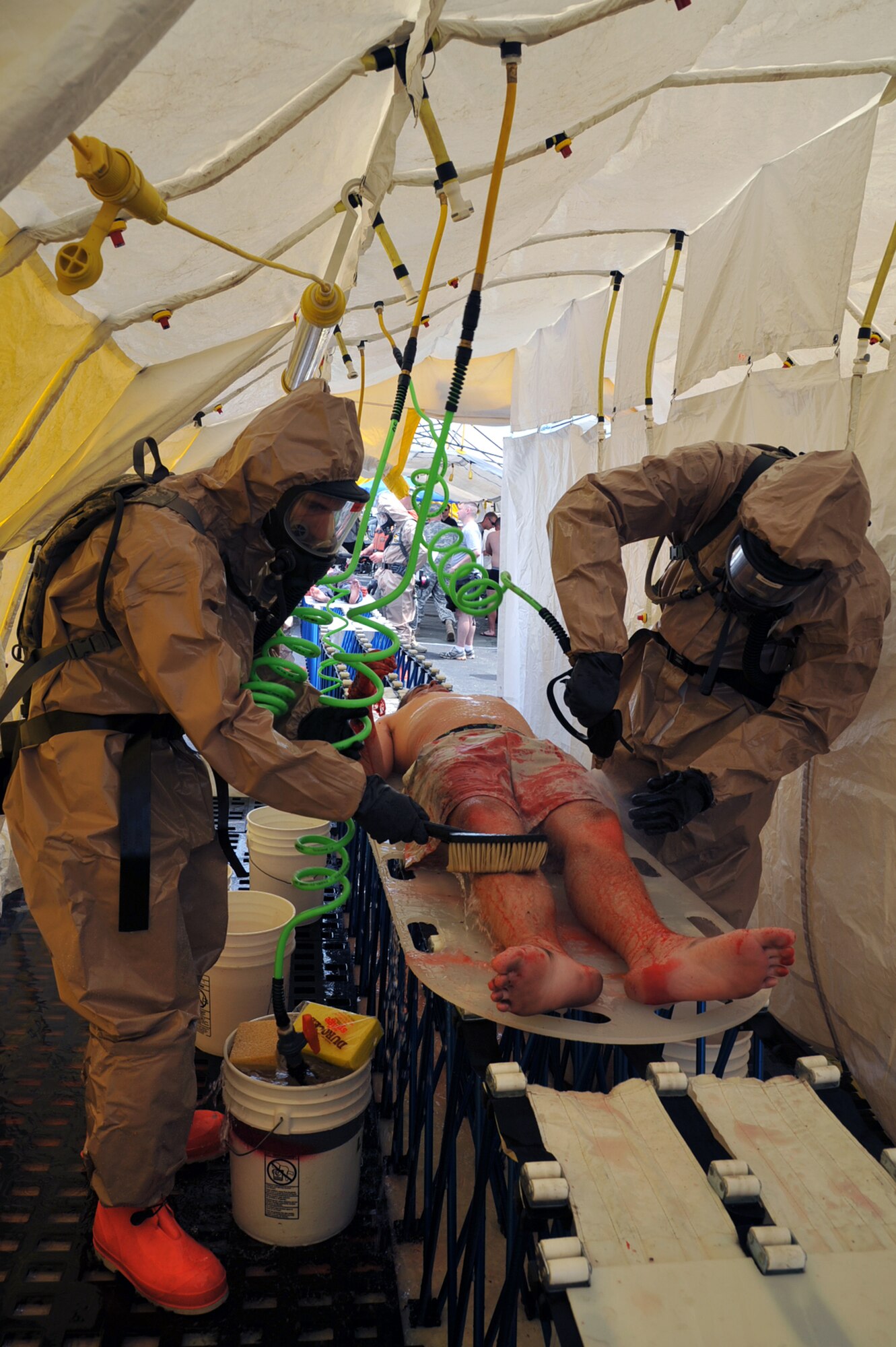 Triage members decontaminate a simulated casualty during the first day of the Hampton Roads Full Scale Exercise staged off the coast of Fort Eustis, Va., May 17, 2011. The three day exercise strengthens anti-terrorism capabilities and tests local, state and federal response efforts in maritime, hostage and mass casualty scenarios.  (U.S. Air Force photo by Airman 1st Class Camilla Griffin) (RELEASED)
