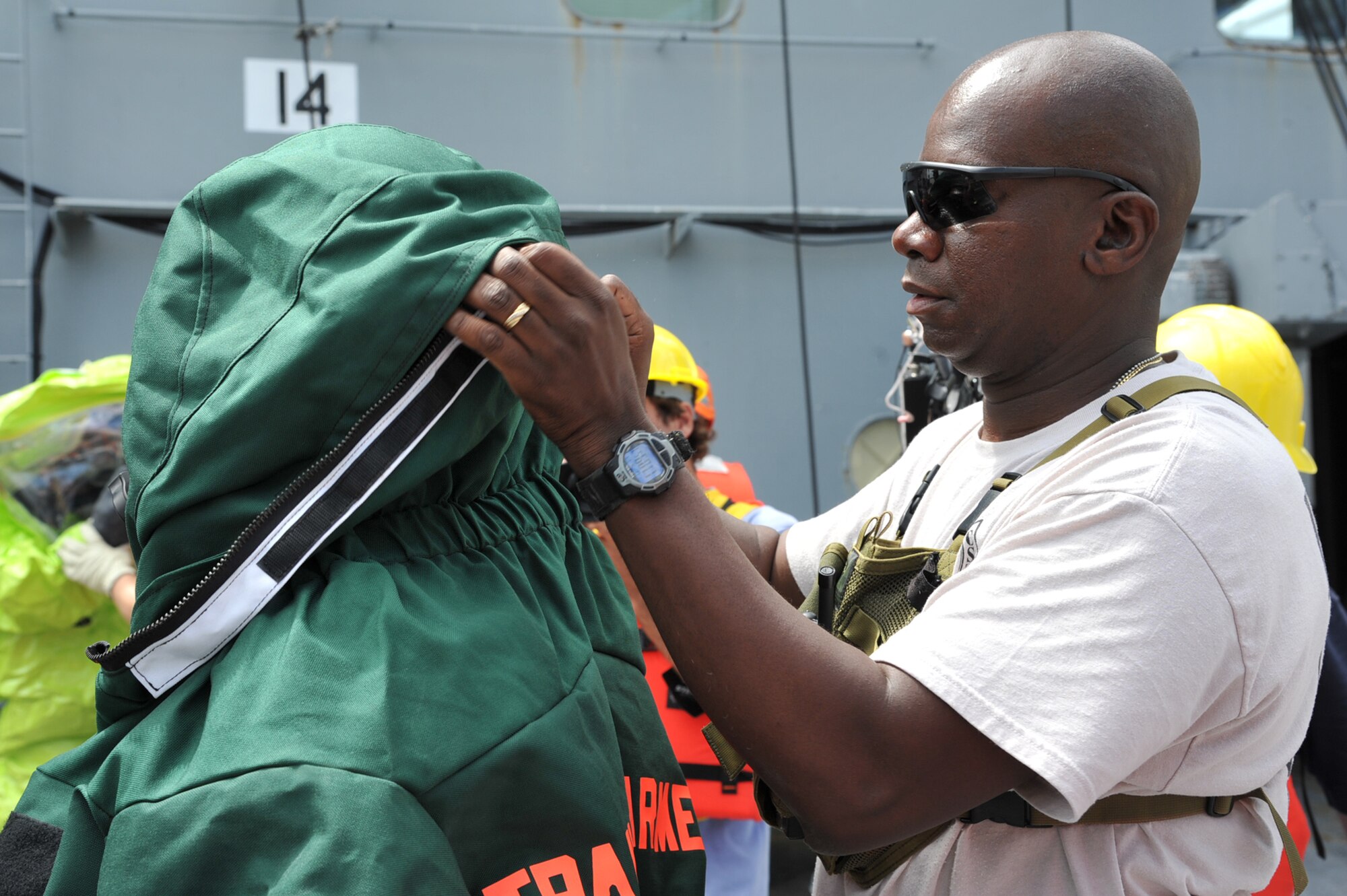 Army Staff Sgt. Winston Obermuller, 34th Civil Support Team server team chief, helps a teammate into a hazardous materials suit during the first day of the Hampton Roads Full Scale Exercise staged off the coast of Fort Eustis, Va., May 17, 2011. The three day exercise strengthens anti-terrorism capabilities and tests local, state and federal response efforts in maritime, hostage and mass casualty scenarios. (U.S. Air Force photo by Airman 1st Class Camilla Griffin) (RELEASED)