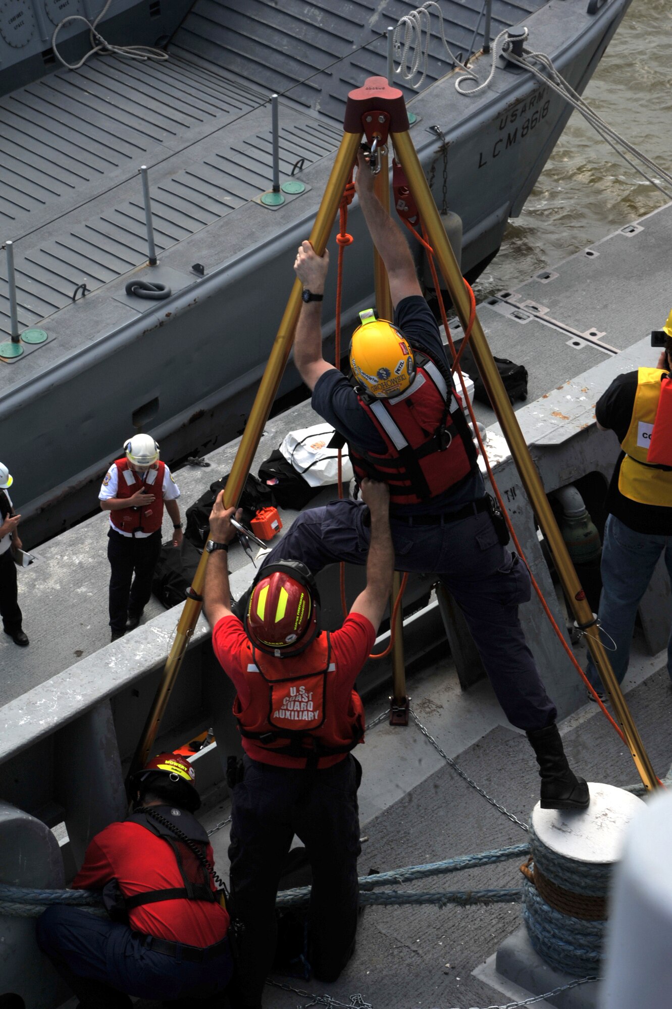 Firefighters set up a pulley system to load cargo onto the "Cape Johnson", the site for the first day of the Hampton Roads Full Scale Exercise staged off the coast of Fort Eustis, Va., May 17, 2011. The three day exercise strengthens anti-terrorism capabilities and tests local, state and federal response efforts in maritime, hostage and mass casualty scenarios. (U.S. Air Force photo by Airman 1st Class Camilla Griffin) (RELEASED)