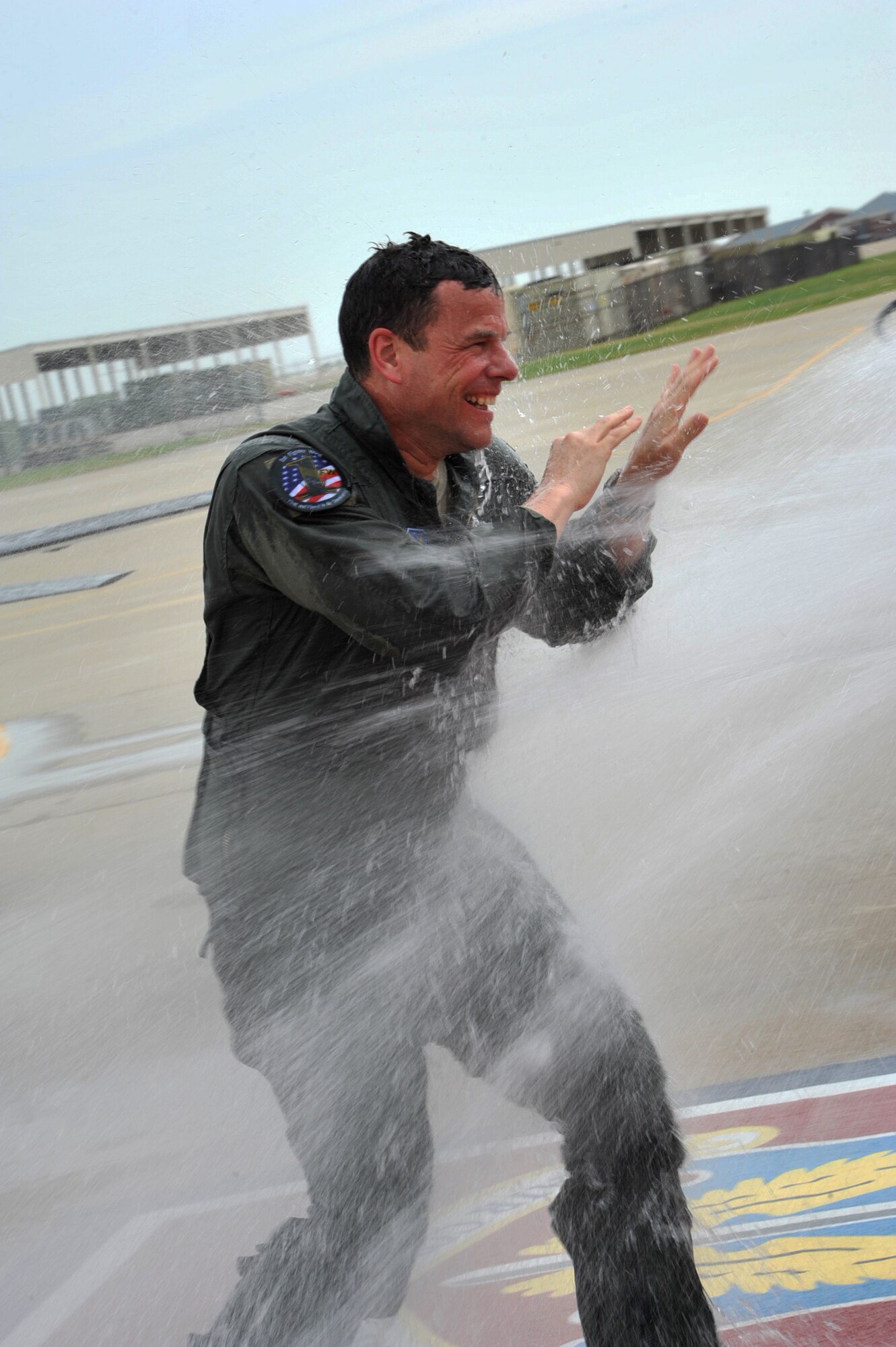 Col. Matthew Molloy, 1st Fighter Wing commander, tries to block water from the fire truck hose Talon after his fini-flight at Langley Air Force Base, Va., May 19, 2011. Colonel Molloy has more than 3,100 flying hours in the F-15 and F-22. (U.S. Air Force photo by Airman 1st Class Camilla Griffin)(RELEASED)