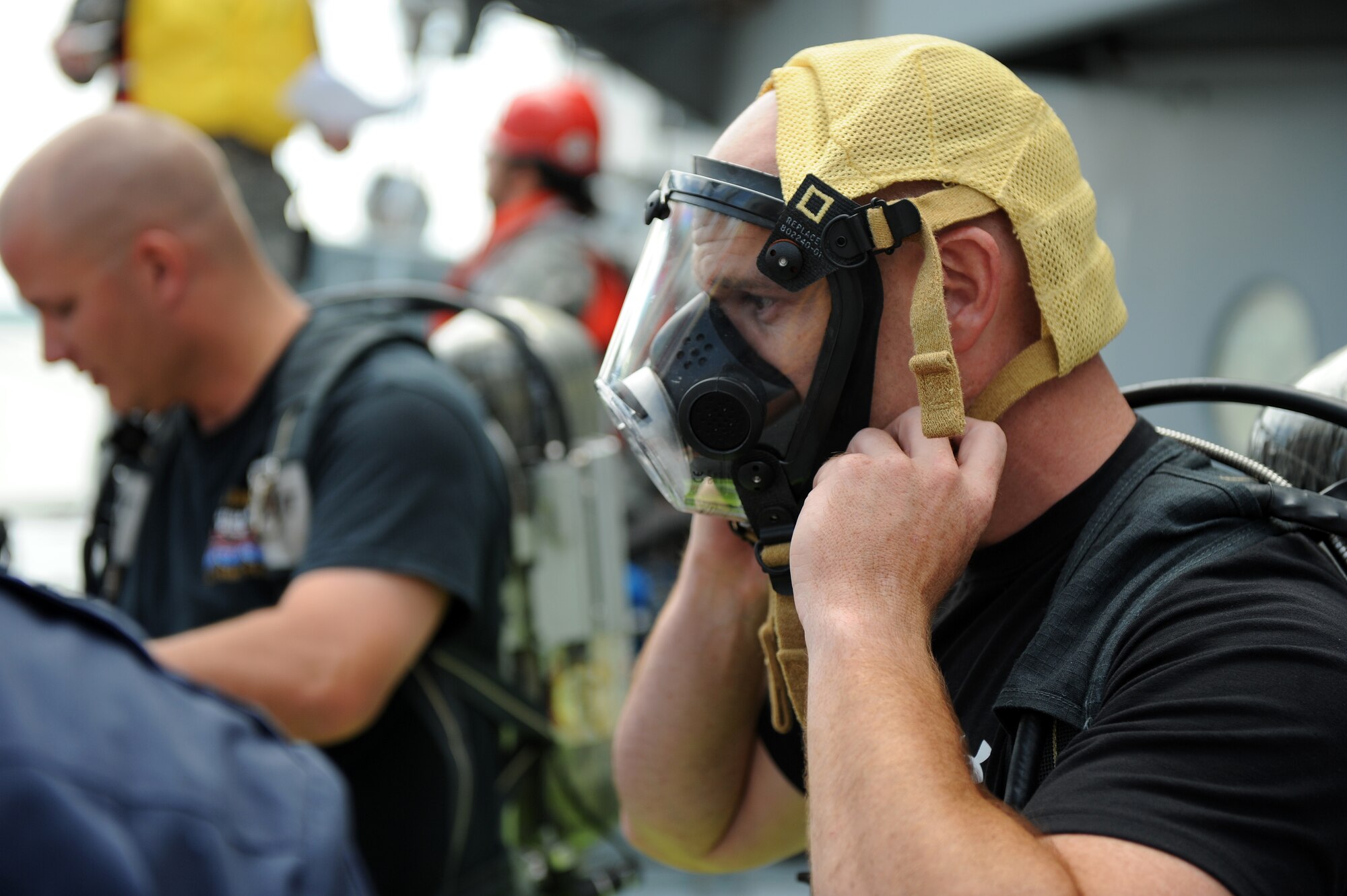 Trooper David Creath, Virginia State Police, dons his gas mask on board the Cape Johnson during the first day of the Hampton Roads Full Scale Exercise staged off the coast of Fort Eustis, Va., May 17, 2011. The three day exercise strengthens anti-terrorism capabilities and tests local, state and federal response efforts in maritime, hostage and mass casualty scenarios. (U.S. Air Force photo by Senior Airman Zachary Wolf)(RELEASED)