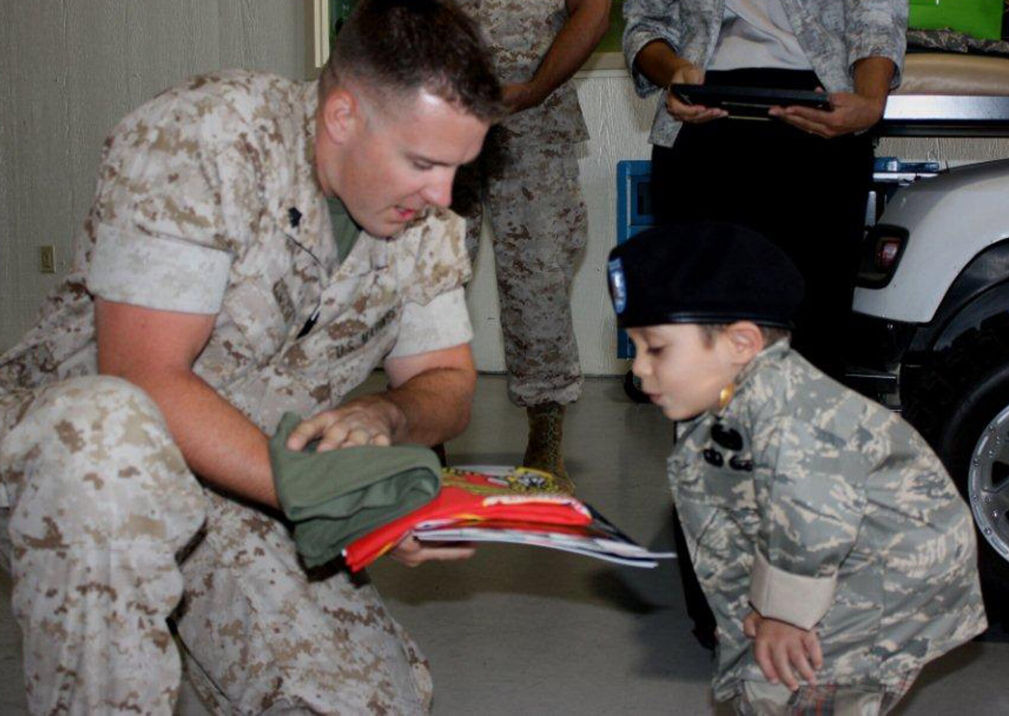 GOODFELLOW AIR FORCE BASE, Texas – Marine Corps Sgt. Robert Tidquist, fire academy instructor, presents Sergeant Major for the day, Shawn Chavez, 8, with gifts that represent the U.S. Marine Corps to include a flag and T-shirt during his tour at the academy May 18.  Servicemembers from the Army, Air Force Navy and Marine Corps hosted Shawn and his family as part of the young boy's wish to meet a Soldier.   He was also presented with items representing each branch of service. (U.S. Army photo/Staff Sgt. Michael Carlson) 