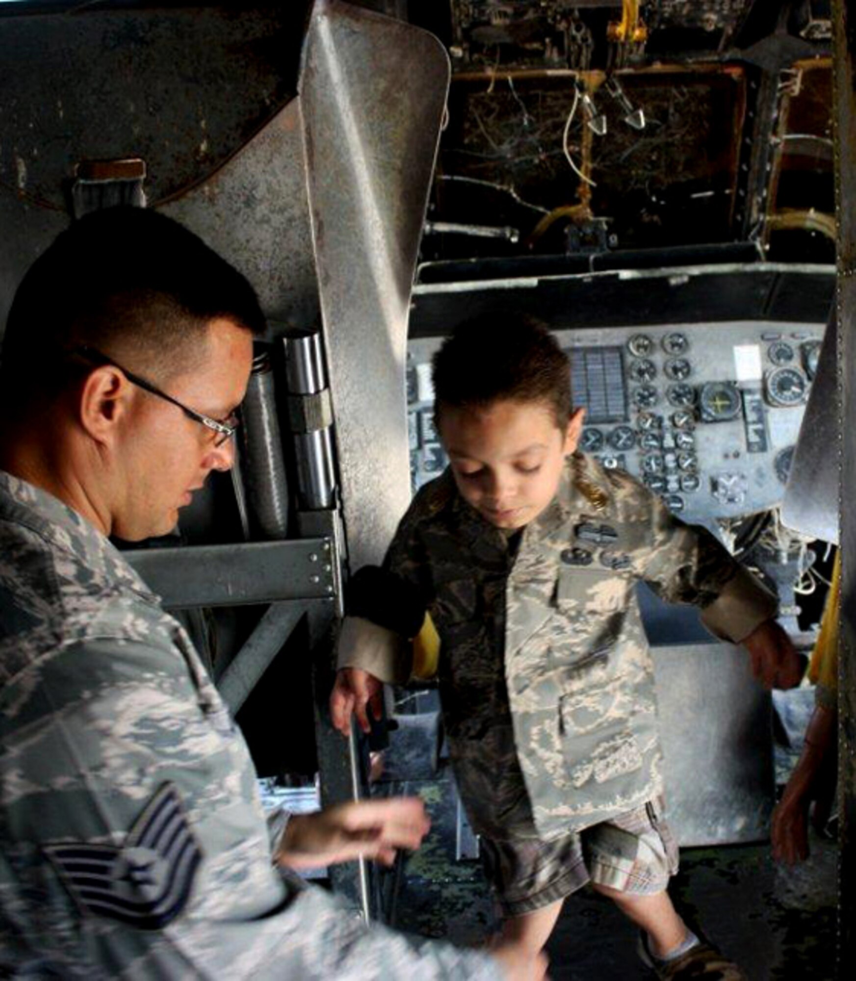 GOODFELLOW AIR FORCE BASE, Texas – Tech. Sgt. Eriberto Ortega, fire academy instructor, shows Sergeant Major for the day Shawn Chavez, 8, around one of the planes firefighters use for training during Shawn's tour at the academy May 18.  Servicemembers from the Army, Air Force Navy and Marine Corps hosted Shawn and his family as part of the young boy's wish to meet a Soldier. (U.S. Army photo/Staff Sgt. Michael Carlson)