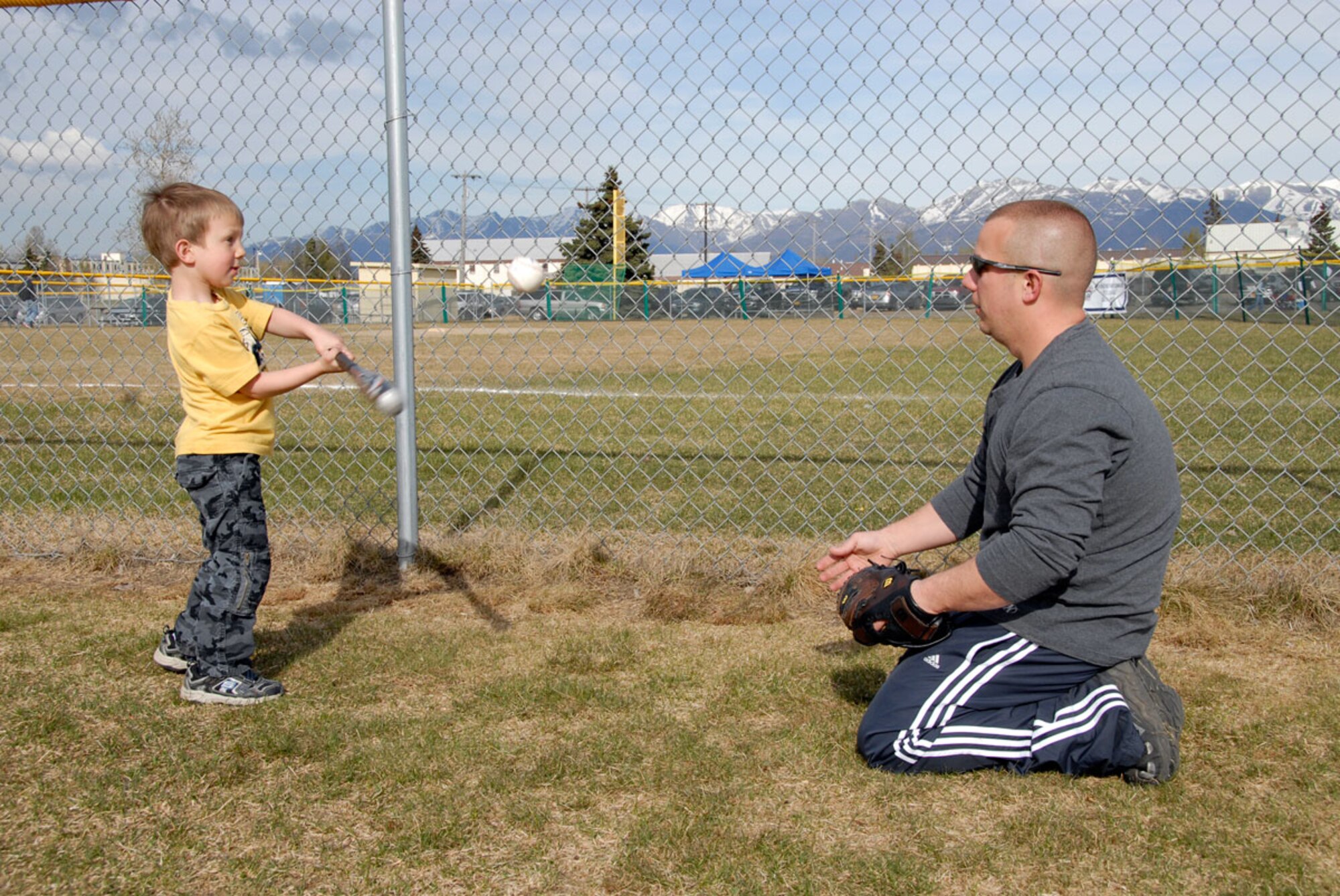 Tech. Sgt. Nolan Busby of the 3d Equipment Maintenance Squadron and his son, Kory, do some batting practice at the Joint Base Elmendorf-Richardson baseball fields.  (U.S. Air Force photo/Steve White)
