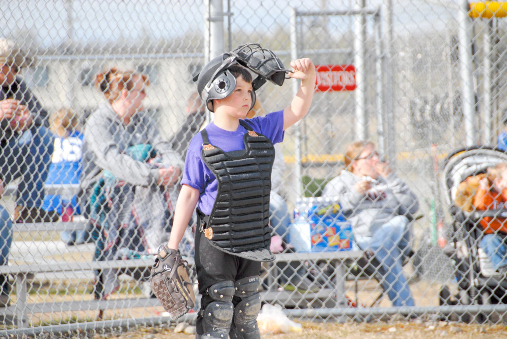 Issac Mitchell, catcher for Joint Base Elmendorf-Richardson’s Rockies Youth Softball Team, looks to the outfield. (U.S. Air Force photo/Steve White)
