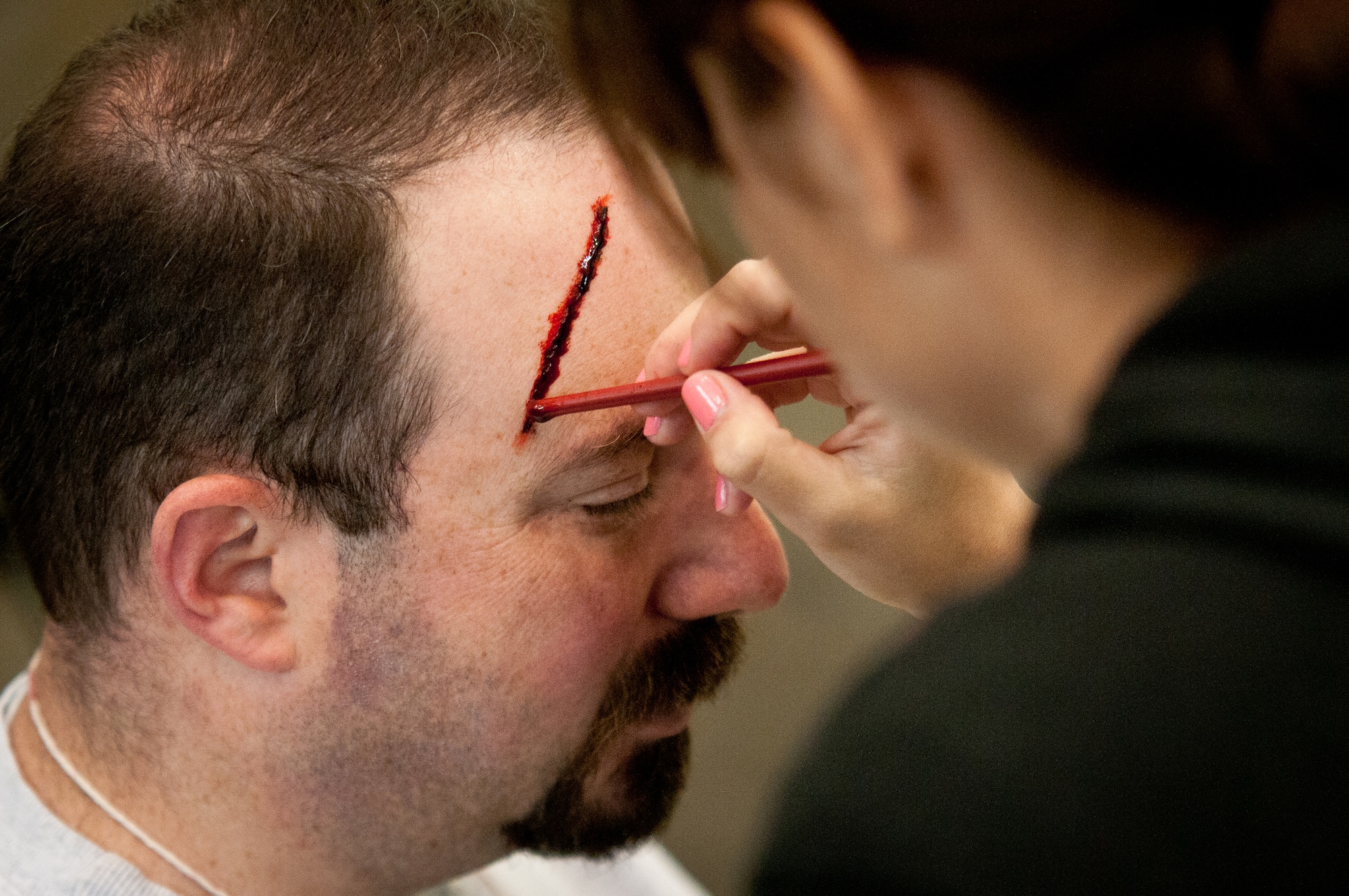 Lee Hyman, a volunteer for the National Disaster Medical System, gets a simulated head laceration applied to his scalp by moulage artist Kelli Morris in preparation for earthquake-response exercises held May 18, 2011, at the Kentucky Air National Guard Base in Louisville, Ky. Operated by the U.S. Department of Health and Human Services, NDMS was created to manage the federal government’s overall medical response to major emergencies and disasters. (U.S. Air Force photo by Maj. Dale Greer)