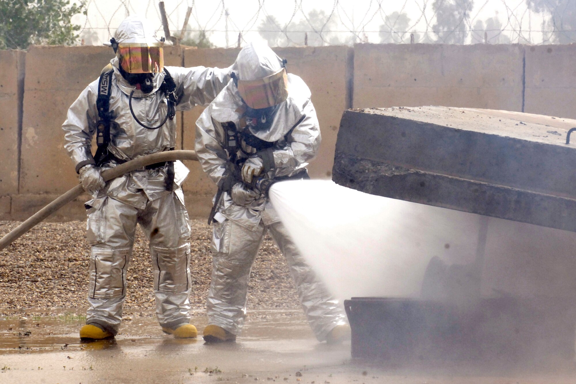 BAGHDAD – Sather Air Base firefighters with Sallyport Co. drown a fire on the aircraft simulator at Baghdad International Airport May 18. The newly completed simulator is the culmination of efforts by multiple organizations in Iraq and will be used to ensure military and civilian firefighters are able to complete annual training requirements. (U.S. Air Force photo by Tech. Sgt. Randy Redman)
