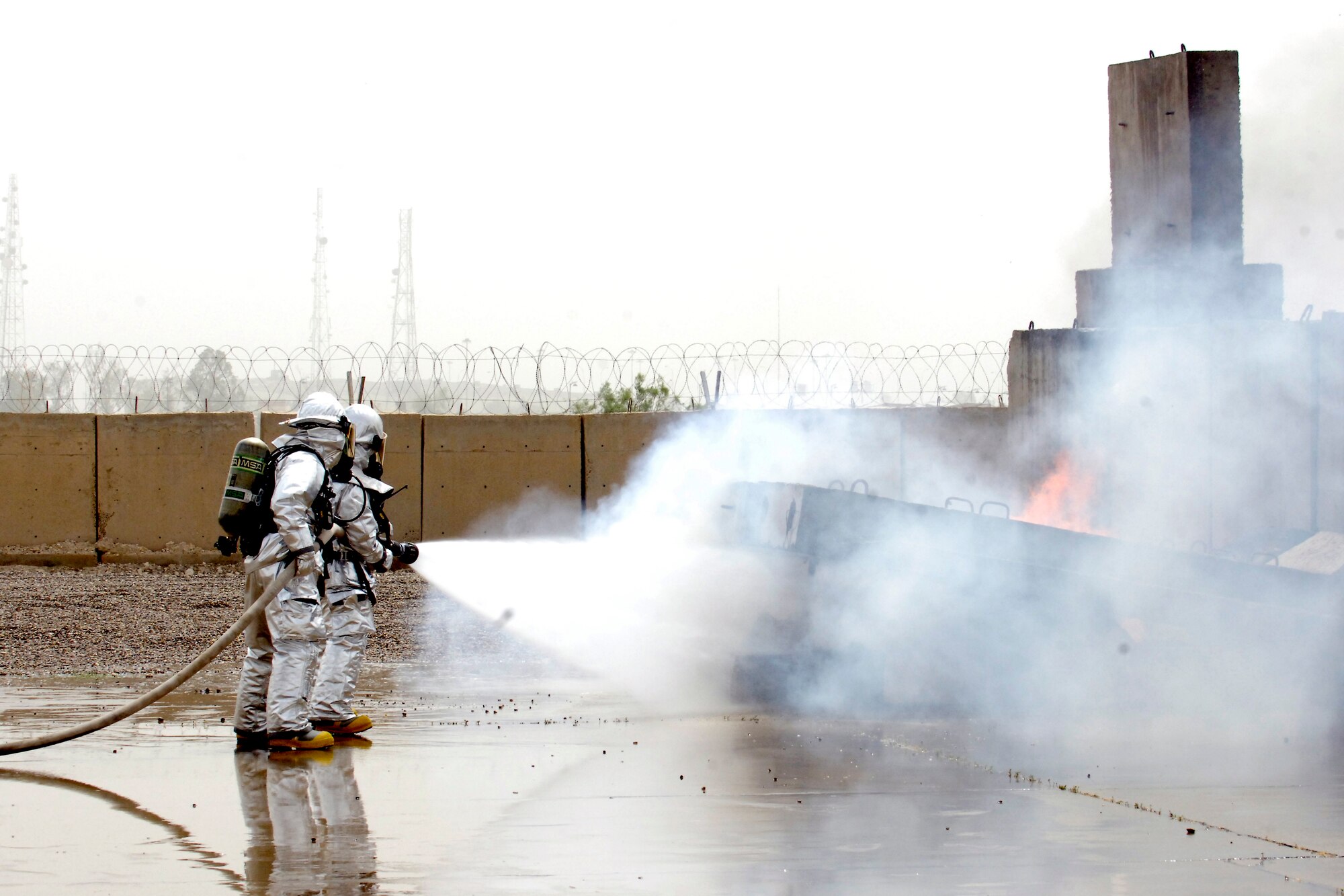 BAGHDAD – Sather Air Base firefighters with Sallyport Co. drown a fire on the aircraft simulator at Baghdad International Airport May 18. The newly completed simulator is the culmination of efforts by multiple organizations in Iraq and will be used to ensure military and civilian firefighters are able to complete annual training requirements. (U.S. Air Force photo by Tech. Sgt. Randy Redman)