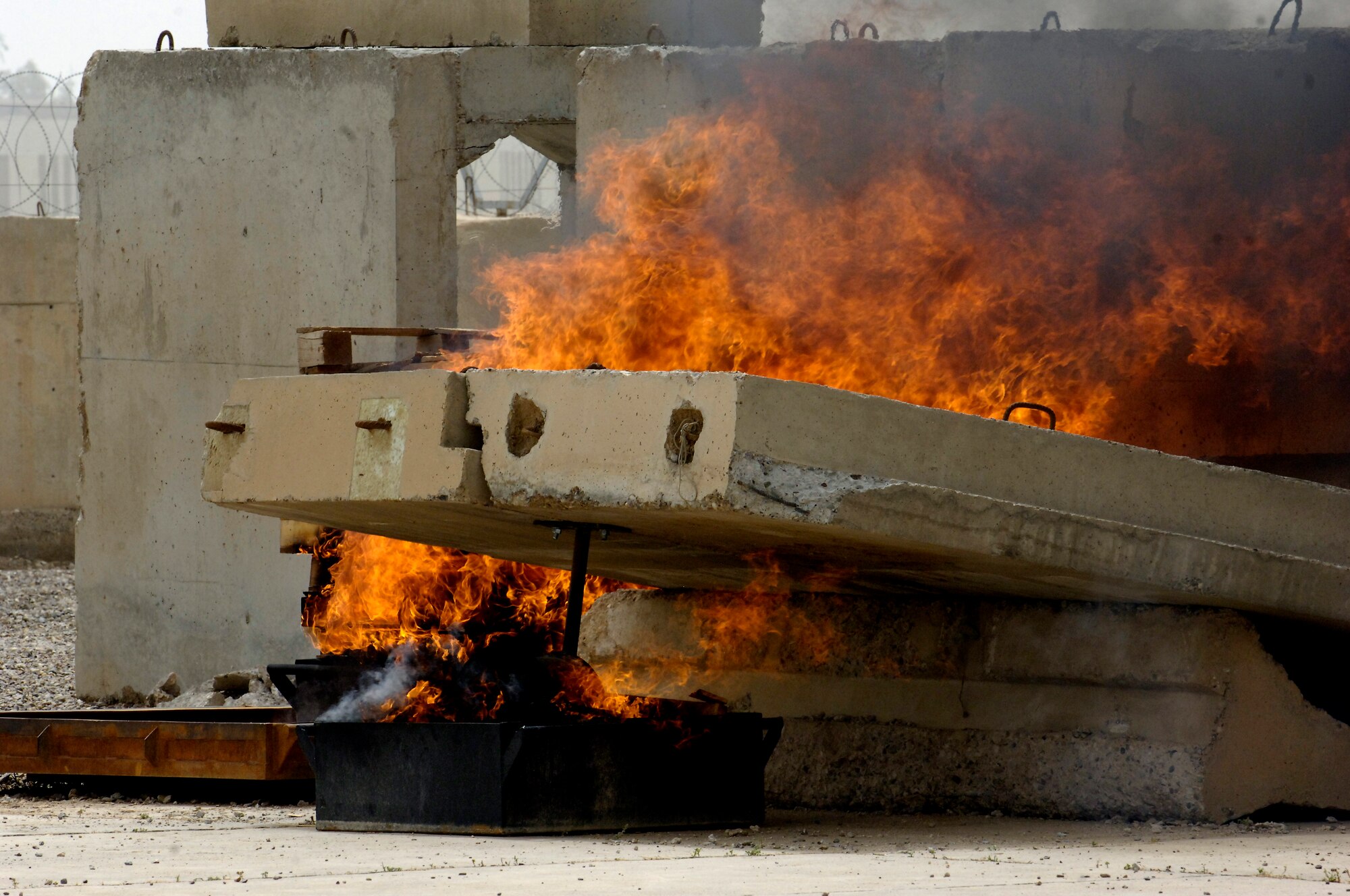 BAGHDAD – A controlled fire builds strength under the “wing” of the aircraft simulator at Baghdad International Airport May 18. The newly completed simulator is the culmination of efforts by multiple organizations in Iraq and will be used to ensure military and civilian firefighters are able to complete annual training requirements. (U.S. Air Force photo by Tech. Sgt. Randy Redman)