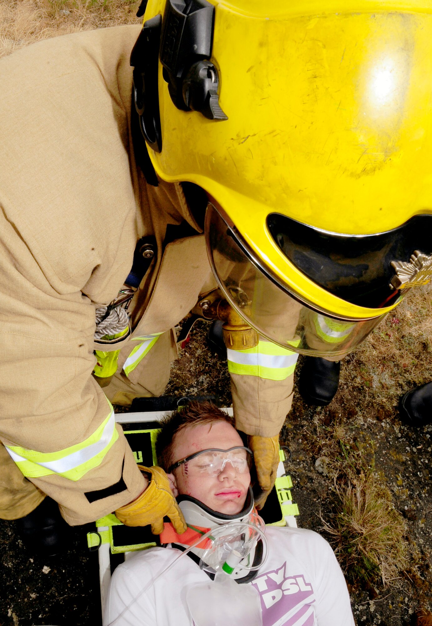 RAF HONINGTON, England -- A British firefighter from Suffolk Fire and Rescue Services supports the neck of a mock plane crash victim during a major accident response exercise held at RAF Honington May 18, 2011. The victims were RAF Mildenhall Airmen who volunteered to provide a more realistic scenario. (U.S. Air Force photo/Senior Airman Ethan Morgan)