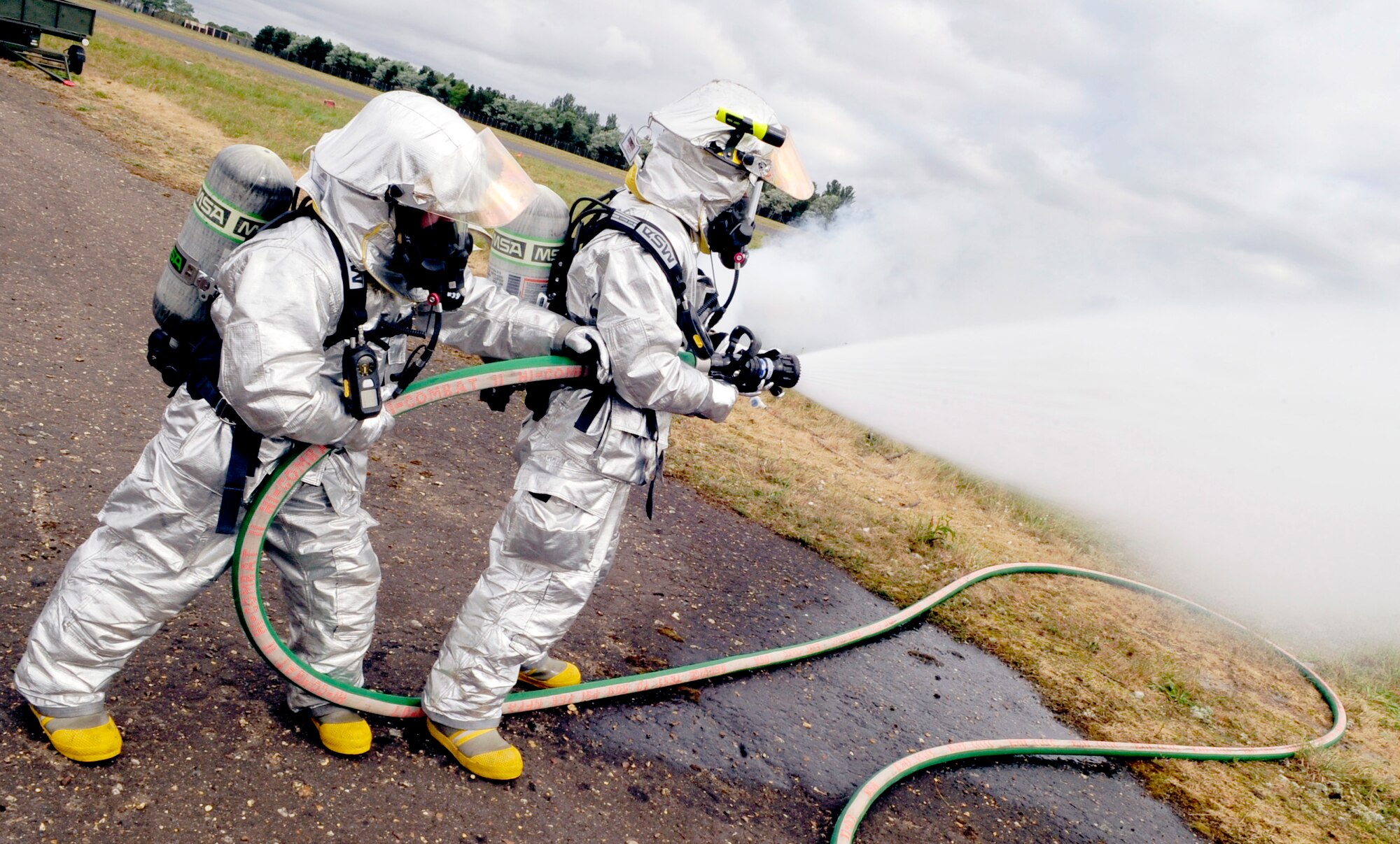 RAF HONINGTON, England -- Two RAF Mildenhall firefighters put out spot fires during a major accident response exercise held at RAF Honington May 18, 2011. The controlled spot fires were started with flares around a mock crash site to simulate burning wreckage and debris. (U.S. Air Force photo/Senior Airman Ethan Morgan)