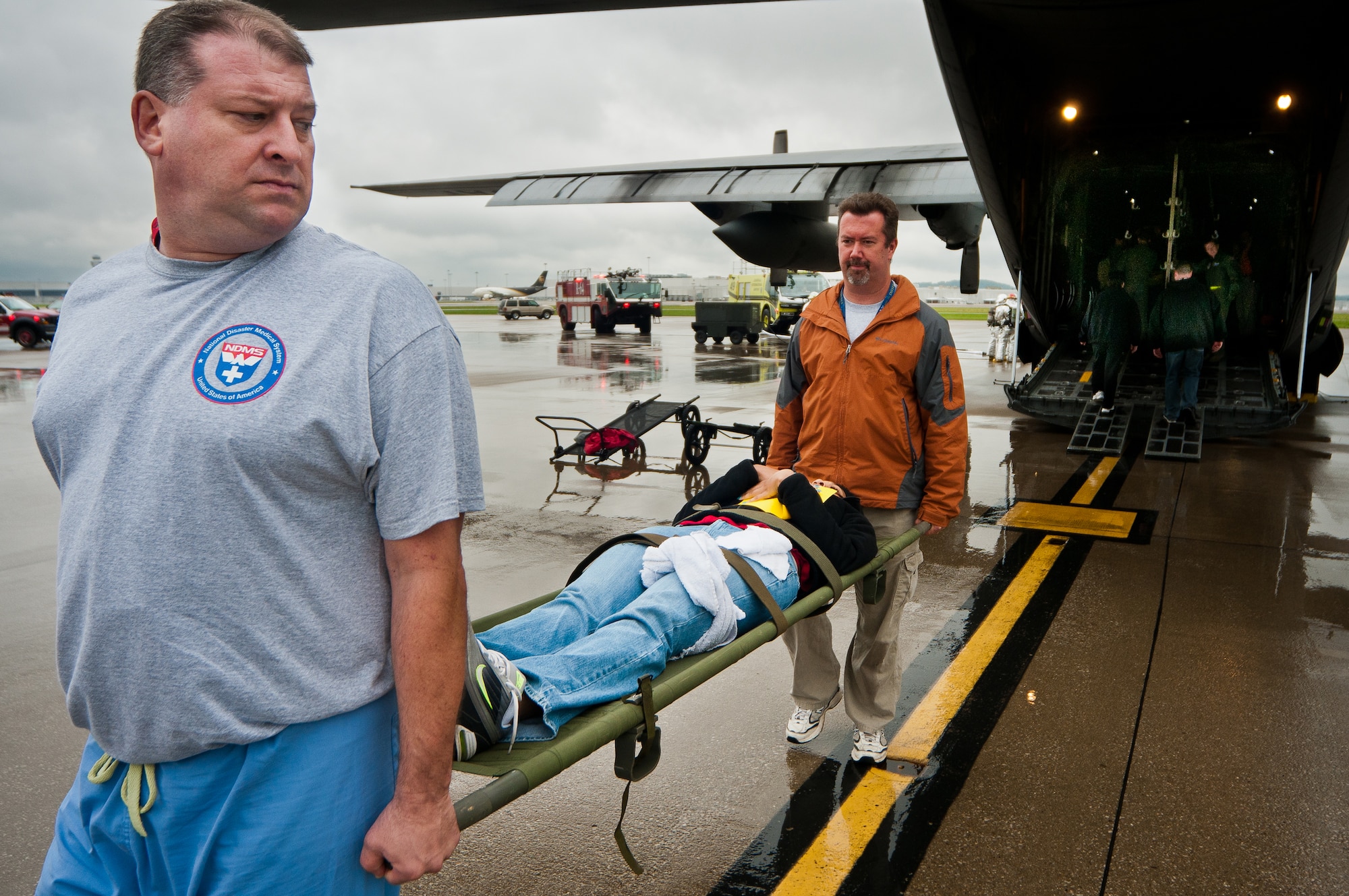 Paul Beard (left), a mental health professional at the Robley Rex Veterans Affairs Medical Center in Louisville, and Troy Colón, an assistive technology professional at the Louisville VA hospital, carry a simulated patient off a Kentucky Air National Guard C-130 during earthquake-response exercises held May 18, 2011, at the Kentucky Air National Guard Base in Louisville, Ky. The exercises were designed to test the capabilities of government agencies following a major earthquake along the New Madrid fault line. (U.S. Air Force photo by Maj. Dale Greer)