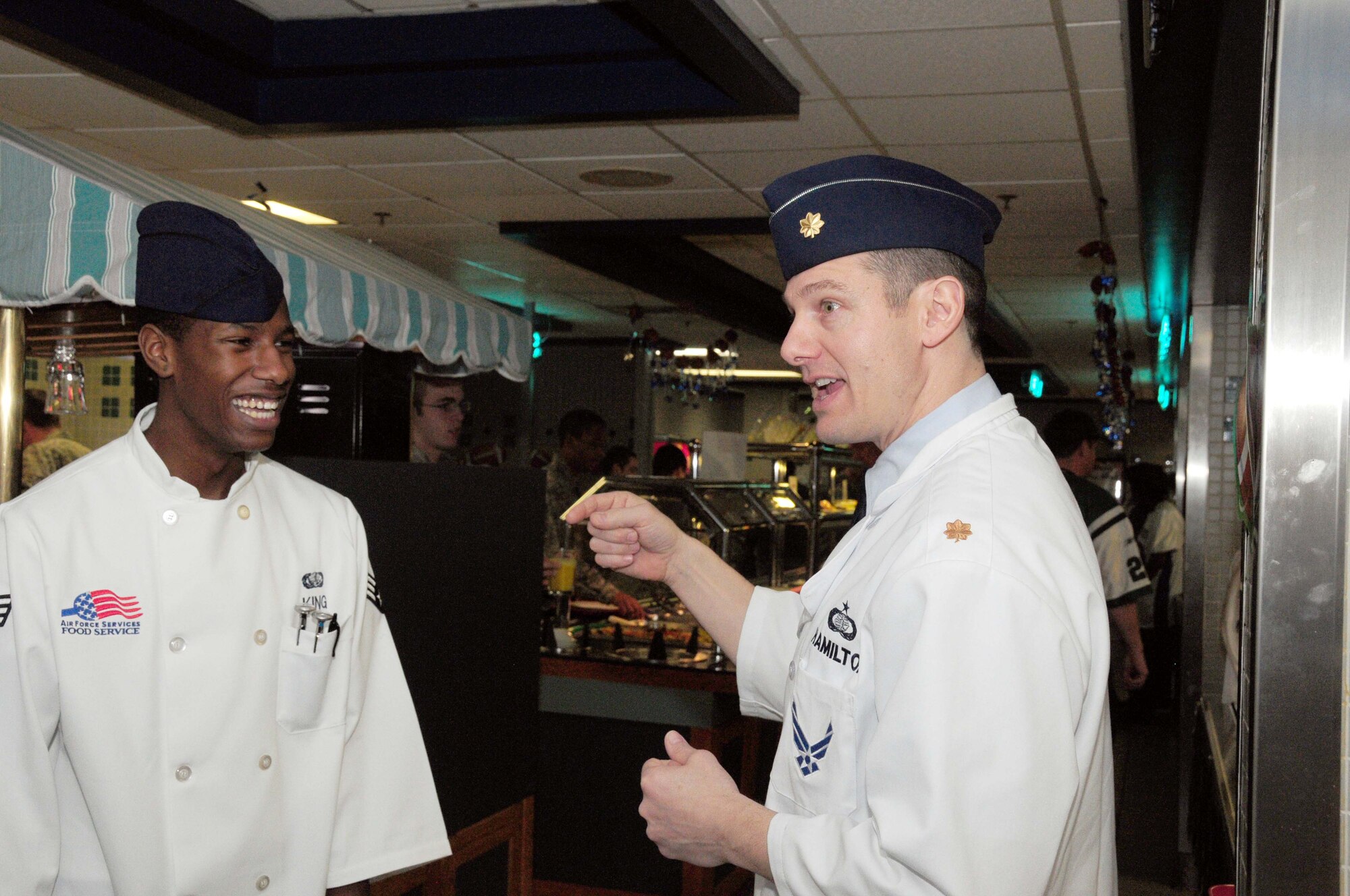 Maj. Charles Hamilton (left), Headquarters Air Force Services Agency, talks with Senior Airman Javan King, 1st Special Operations Force Support Squadron, during the Reef Dining Facility’s evaluation at Hurlburt Field, Fla., in February 2011. The Hennessy trophy is presented annually to the installation with the best food service programs in the entire Air Force. (courtesy photo)