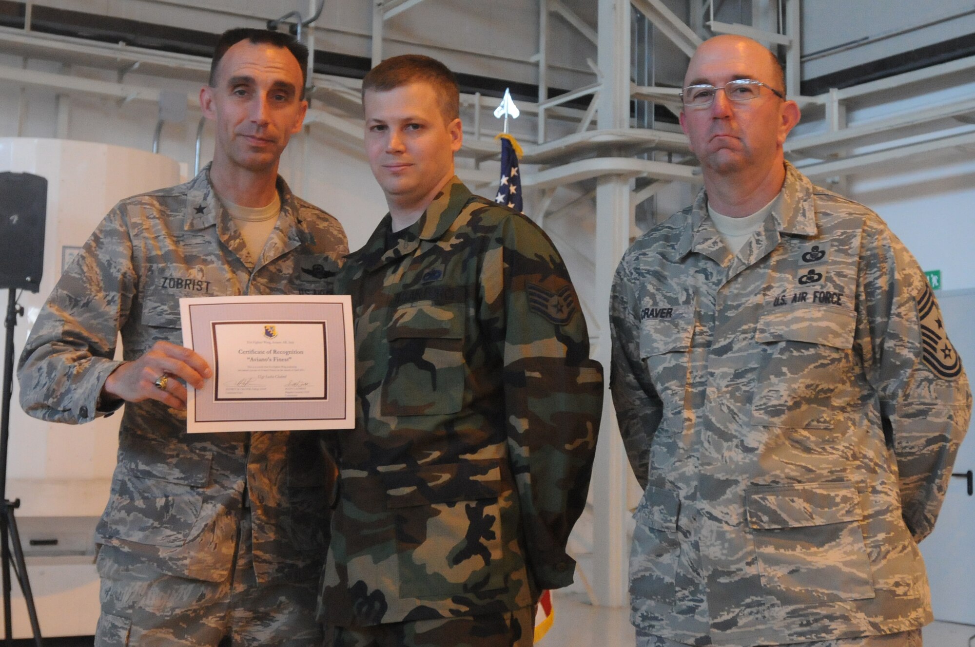 Brig. Gen. Scott J. Zobrist, 31st Fighter Wing commander, and Chief Master Sgt. Jeffrey Craver, 31st FW command chief, congratulate Staff Sgt. Sasha Chabrel, 31st Maintenance Squadron aerospace ground equipment craftsman, on his selection as one of Aviano's Finest May 17.(U.S. Air Force photo/Airman 1st Class LaVel Sterling)
