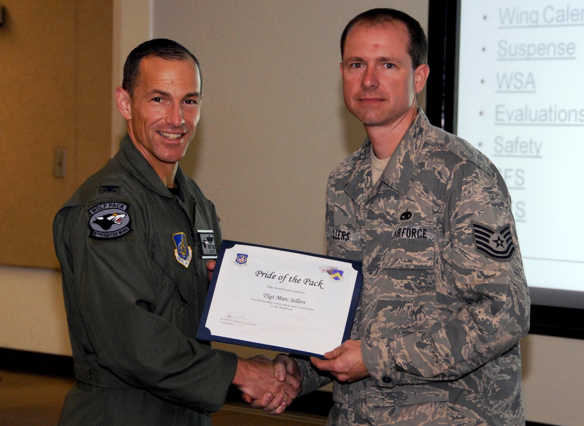 KUNSAN AIR BASE, Republic of Korea -- Col. Scott Pleus, 8th Fighter Wing commander, presents Tech. Sgt. Marc Sellers, 8th Maintenance Squadron aircraft metals technology NCO-in-charge, with a Pride of the Pack award here May 19. (U.S. Air Force photo/Capt. Sheryll Klinkel)