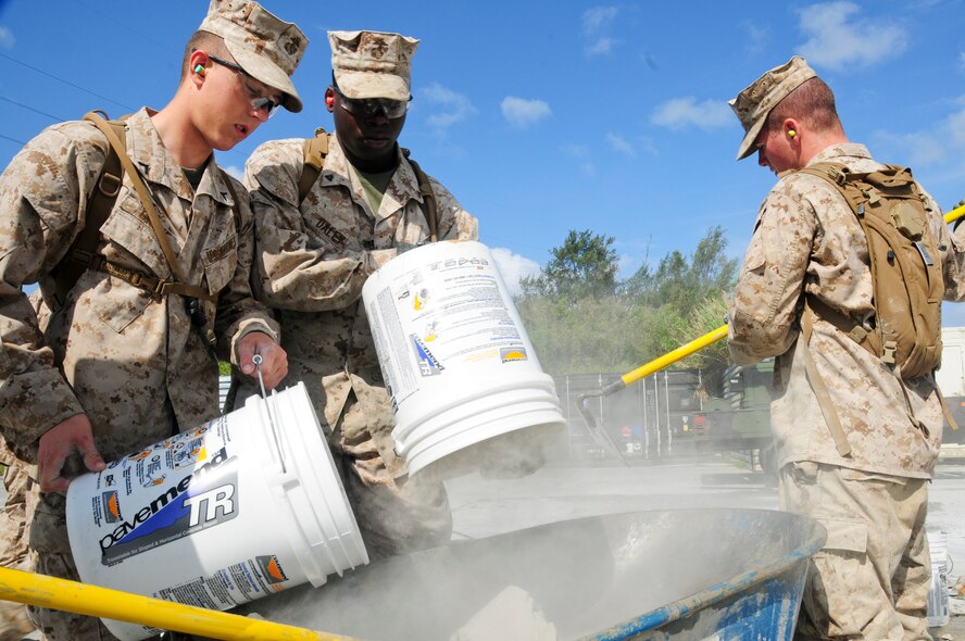 Marines assigned to Camp Foster's Marine Wing Support Squadron 172 mix quick-drying cement as they work against the clock to repair spalled concrete at Kadena's Silver Flag site. The air base's 554th RED HORSE Squadron hosted a week-long training camp for the Marines, teaching techniques in heavy equipment operation and rapid runway repair methods unique to the Air Force. (U.S. Air Force photo/Senior Airman Shaunlee Hostutler)