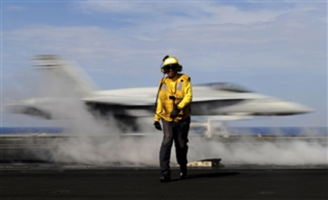 Petty Officer 2nd Class Jason Querido, assigned to the air department of the aircraft carrier USS Carl Vinson (CVN 70), works as an aircraft director on the flight deck in the Pacific Ocean on May 13, 2011.  The Carl Vinson and Carrier Air Wing 17 are underway in the U.S. 7th Fleet area of responsibility.  