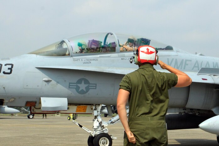 A Marine All-Weather Fighter Attack Squadron 242 ordnance technician salutes a VMFA(AW)-242 pilot and a weapon systems officer before they take off from the flight line here May 19. VMFA(AW)-242 launched its jets to conduct ongoing simulated air-to-air combat training with elements of the Japan Air Self-Defense Force. VMFA(AW)-242 wrapped up its third week of the newly implimented air-to-air trianing with the Western Air Defense Force 8th Air Wing’s F-15J 204th and F-2A 6th JASDF Tactical Fighter Squadrons from Tsuiki Air Base.