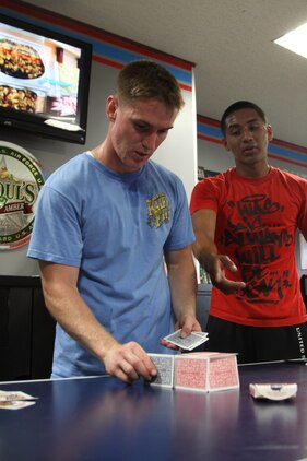 Vonace Creswellmcdermett, Beast Mode team member, builds a second house of cards at the Marine Lounge station here during the 2011 Amazing Race May 20. Team members had to build three card houses. Once one was built the next team member added on to the previous, building the next house, a fourth house gave a time bonus.