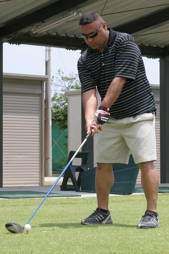 Rodney M. Buentello lines up his golf club before swinging during the Marine Aircraft Group 12 sponsored golf tournament at the Torii Pines Golf Course here May 20. The purpose of the tournament was to bring about unit cohesion and morale. More than 40 Marines and sailors took part in the tournament.