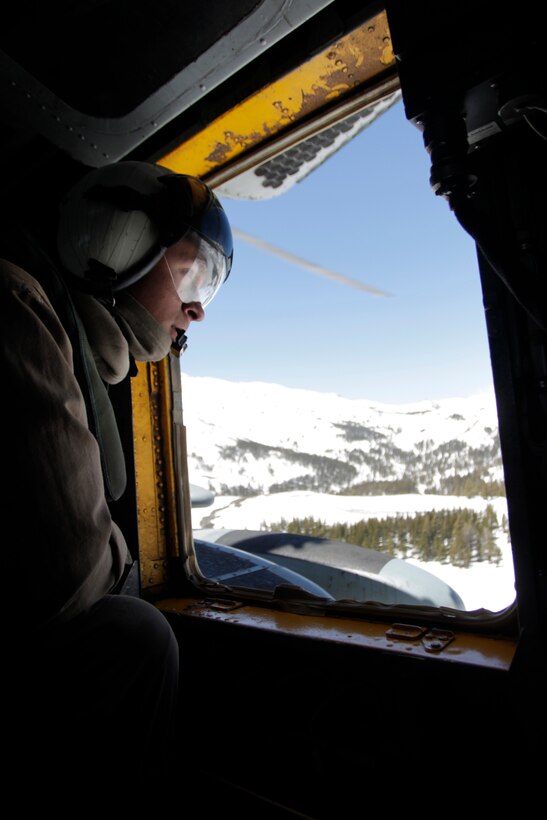 A crew chief from HMH-361, looks out the window of a CH-53E Super Stallion during a flight over the MWTC, Bridgeport, Calif. Many of the pilots have never flown in the center’s high altitude and snowy conditions.