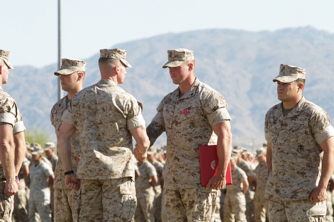 Corporal Edward Huth, a section leader with Weapons Company, 3rd Battalion, 7th Marine Regiment, accepts his Bronze Star Medal with a handshake from the battalion commander at Felix Field May 27, 2011.