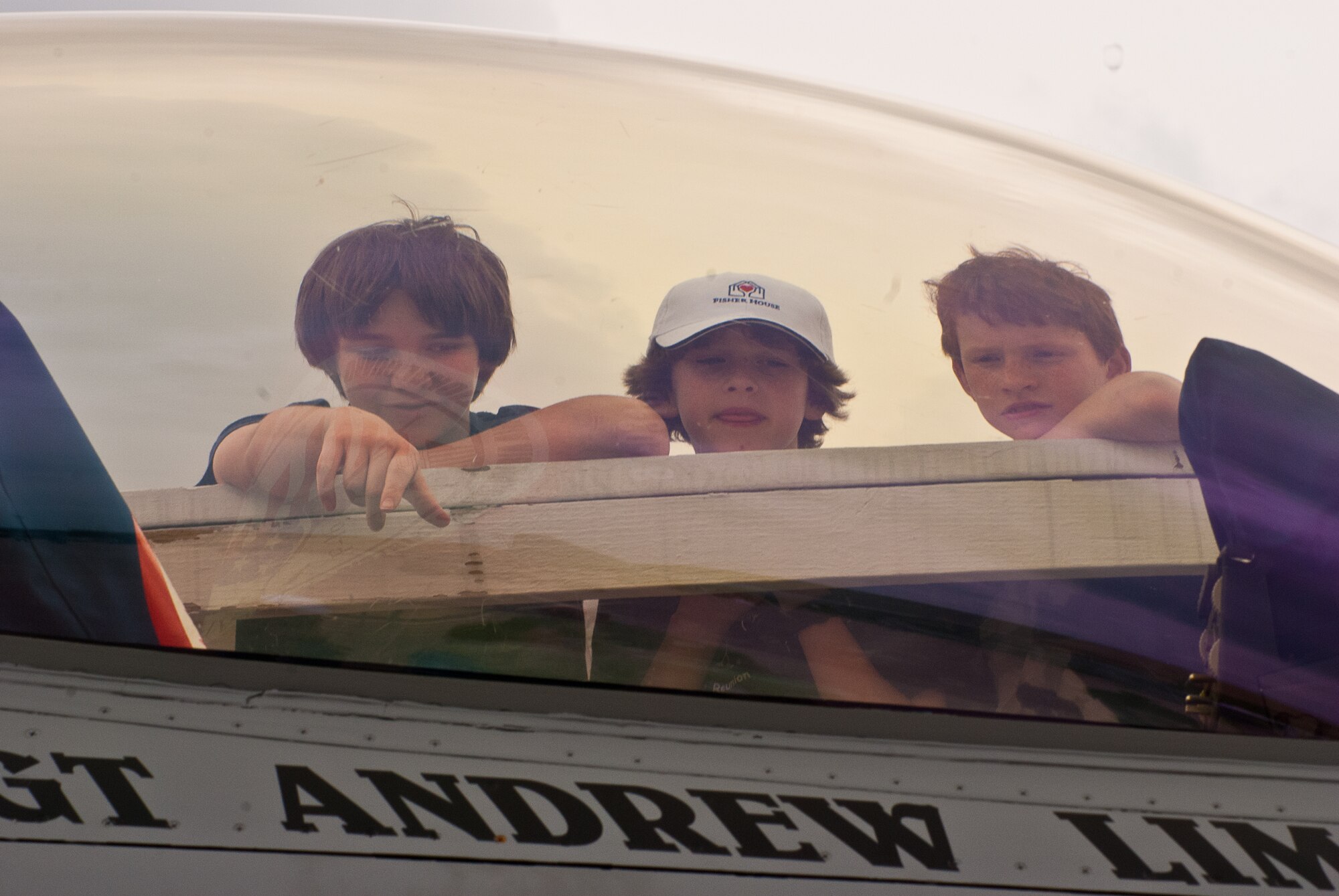 JOINT BASE ANDREWS, Md. -- Pilot for a Day alum (left to right), Sam Gates, Andrew McMichael and Joe Barnes look inside the cockpit of a F-16 Fighting Falcon at the Joint Services Open House here May 20. Earlier, the children attended the Pilot for a Day 2011 Reunion sponsored by the 201st Airlift Wing, the 113th Wing and the 459th Air Refueling Wing. The Pilot for a Day program offers children with serious illnesses a special day to be an Air Force pilot, giving them a break from whatever challenges they may face. (U.S. Air Force photo/ Staff Sgt. Sophia Piellusch)