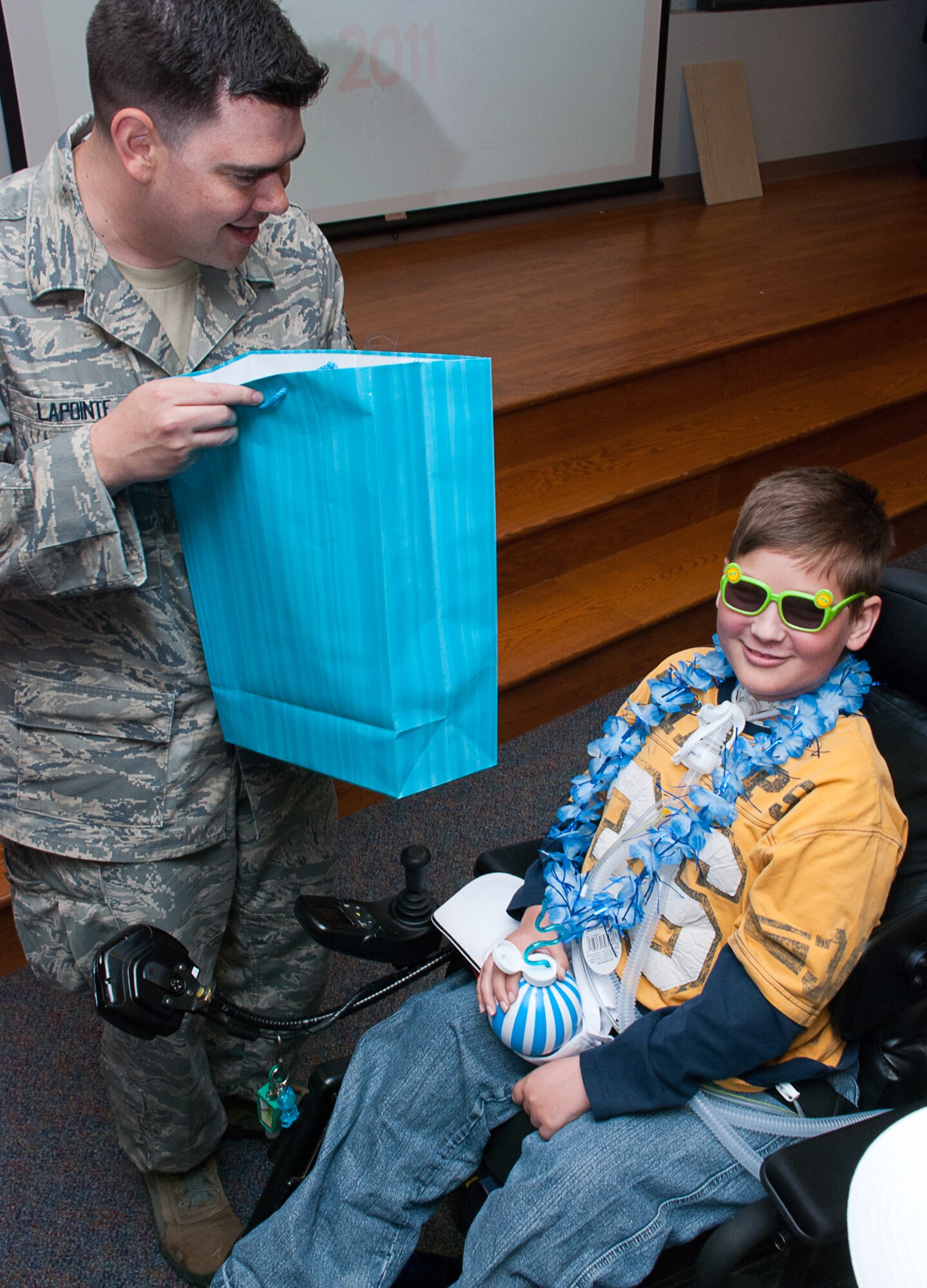 JOINT BASE ANDREWS, Md. -- Master Sgt. Drew Lapointe, Air National Guard Bureau, holds a goody bag as Isaiah Horst, Pilot for a Day alum, looks cool here May 20. The 201st Airlift Wing, The 113th Wing and The 459th Air Refueling Wing sponsored the Pilot for a Day 2011 Reunion during the Joint Service Open House. The Pilot for a Daynprogram offers kids with serious illnesses a special day to be an Air Force pilot, giving them a break from whatever challenges they may face. (U.S. Air Force photo/ Staff Sgt. Sophia Piellusch)
