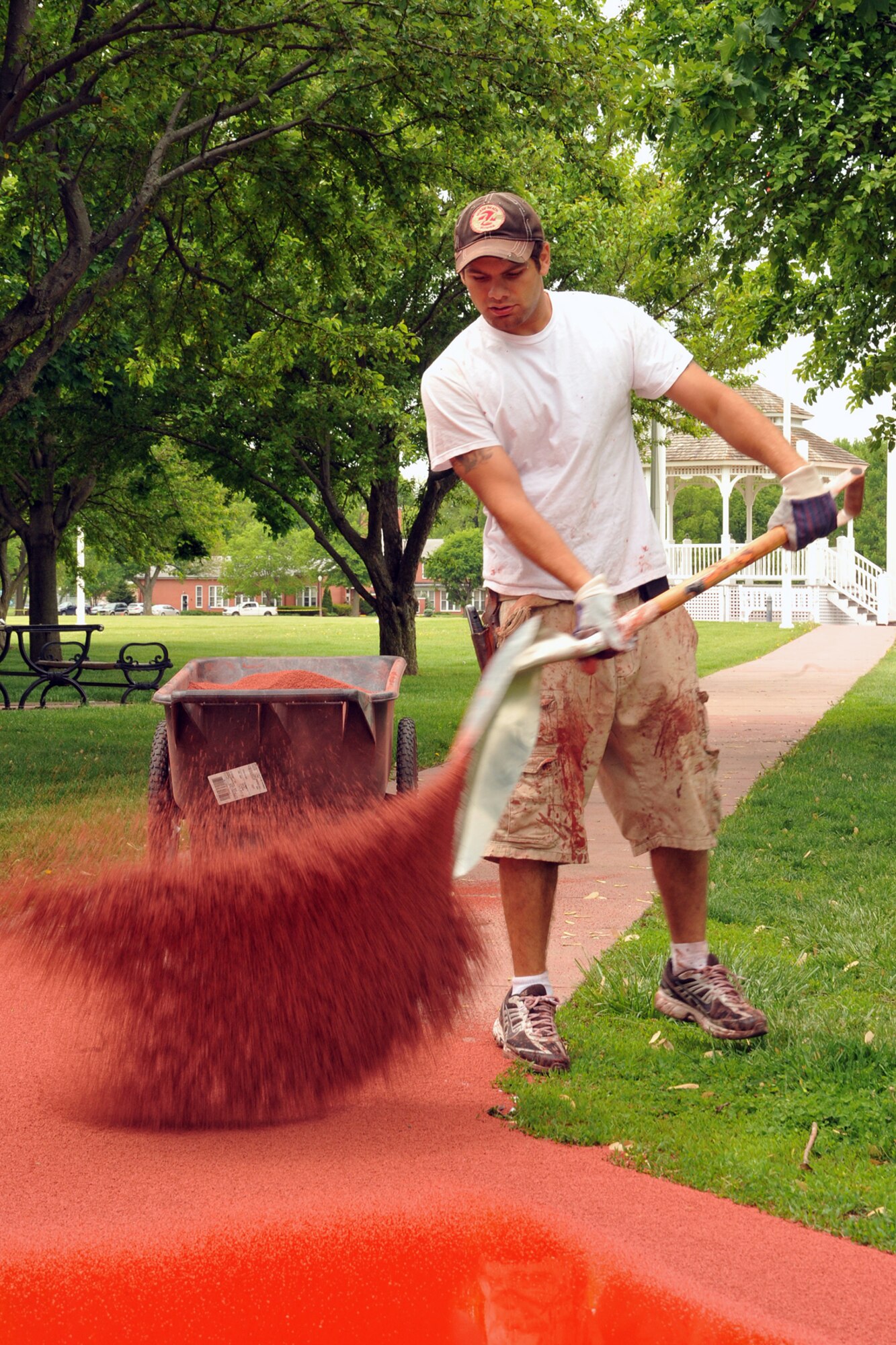 OFFUTT AIR FORCE BASE, Neb. -- Armon Niliaran of Bynon Sports, spreads rubber particles over a coating of primer that was poured on the surface on the track around the parade field at Offutt Air Force Base on May 18.  Bynon Sports, which is located in Hunt Valley, Maryland was contracted to cover the concrete track at the Offutt parade field with a rubber surface. U.S. Air Force Photo by D.P. Heard
